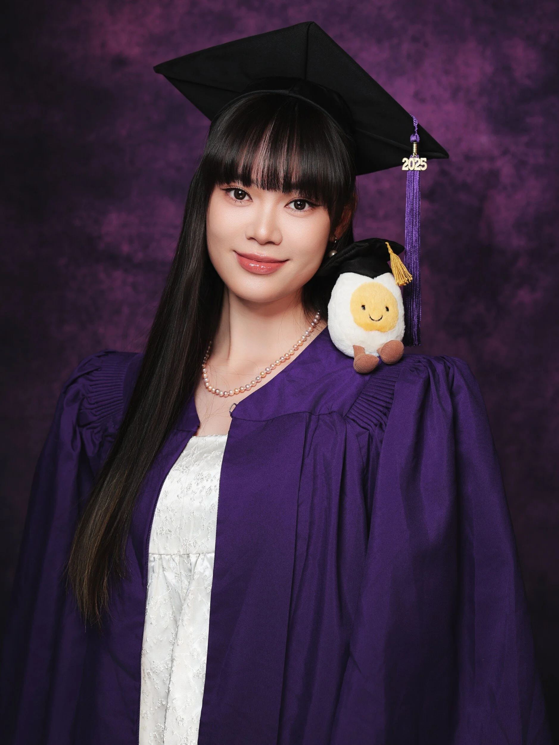 NYU graduate with bangs and a plush toy on her shoulder