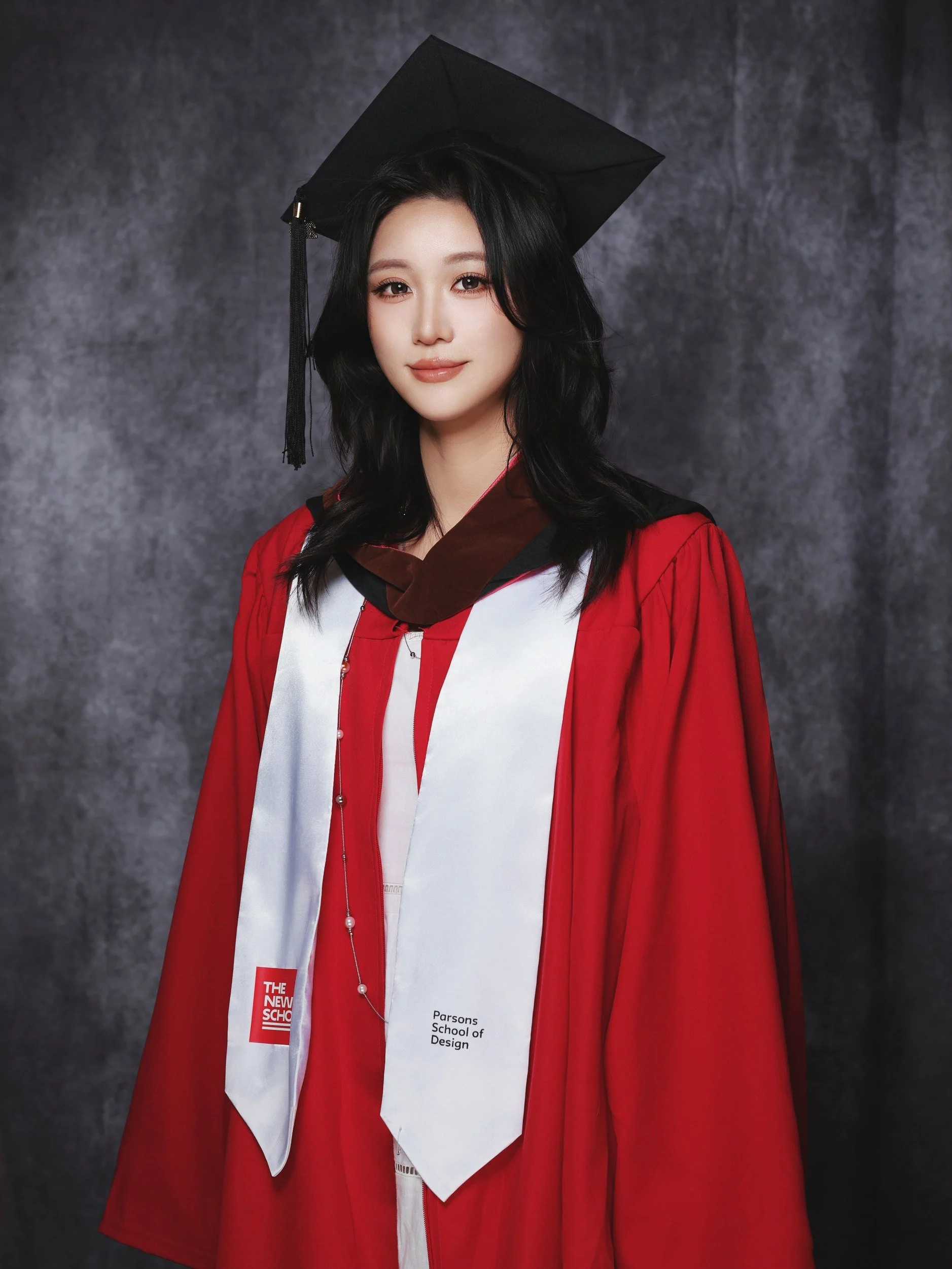 Graduation portrait of a woman in a red gown and cap