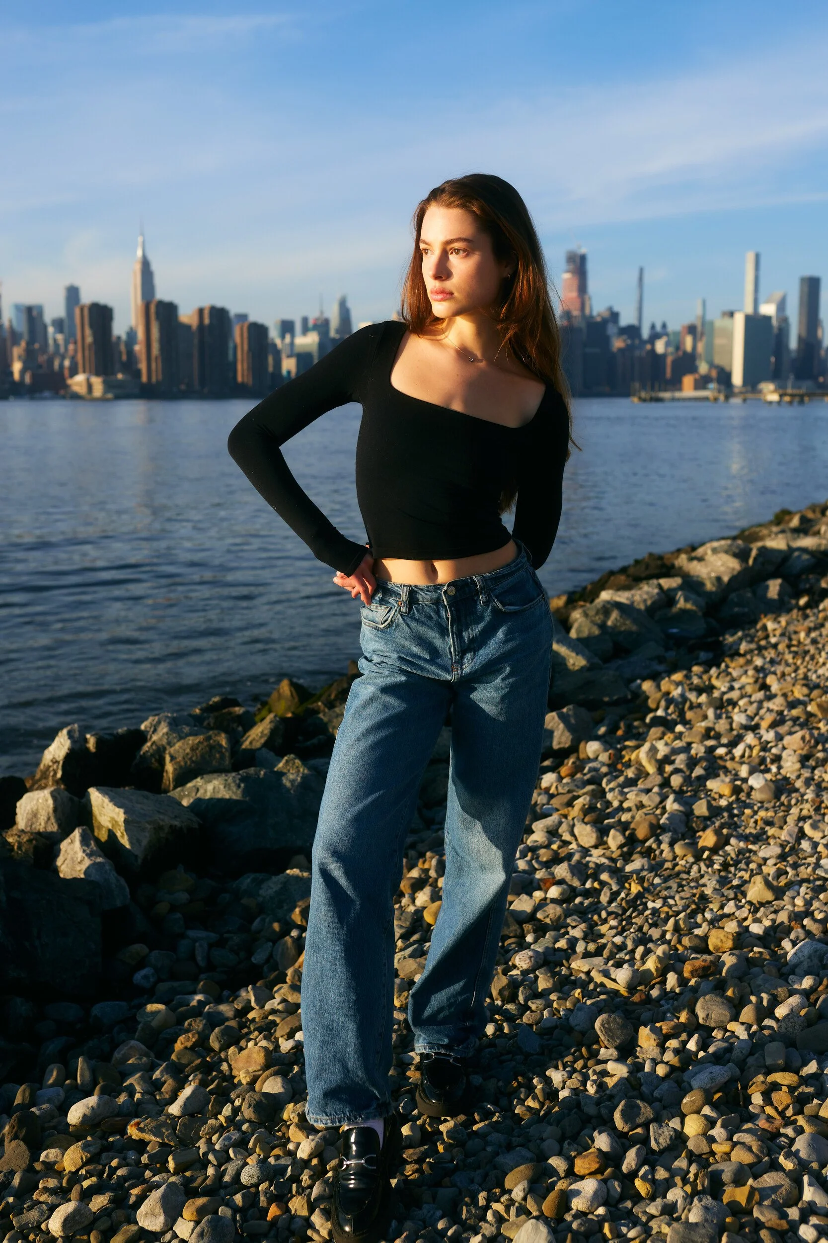 Model digitals by the river: the female model posing with a hand on her hip