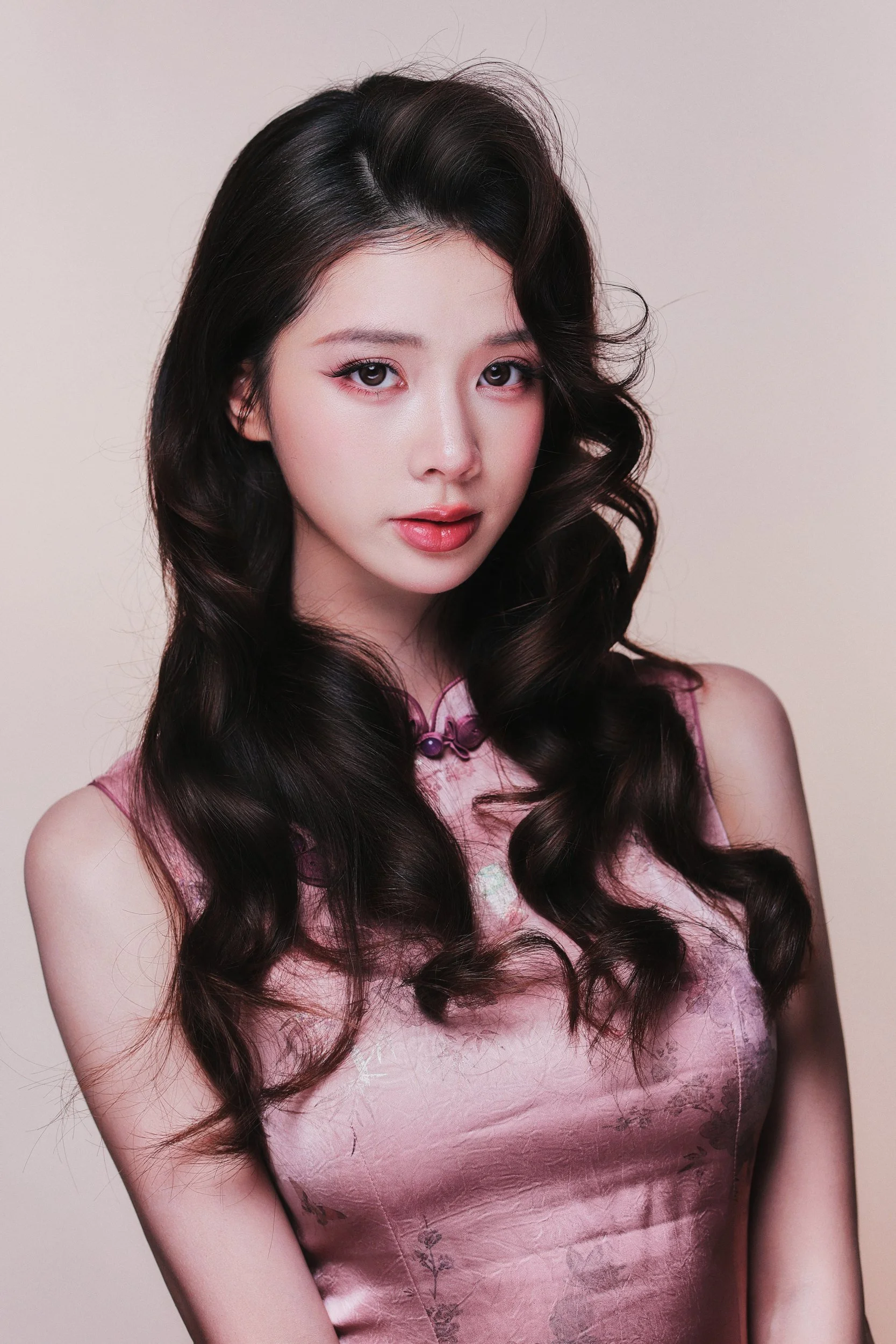 Half-length studio portrait of a woman in a pink qipao