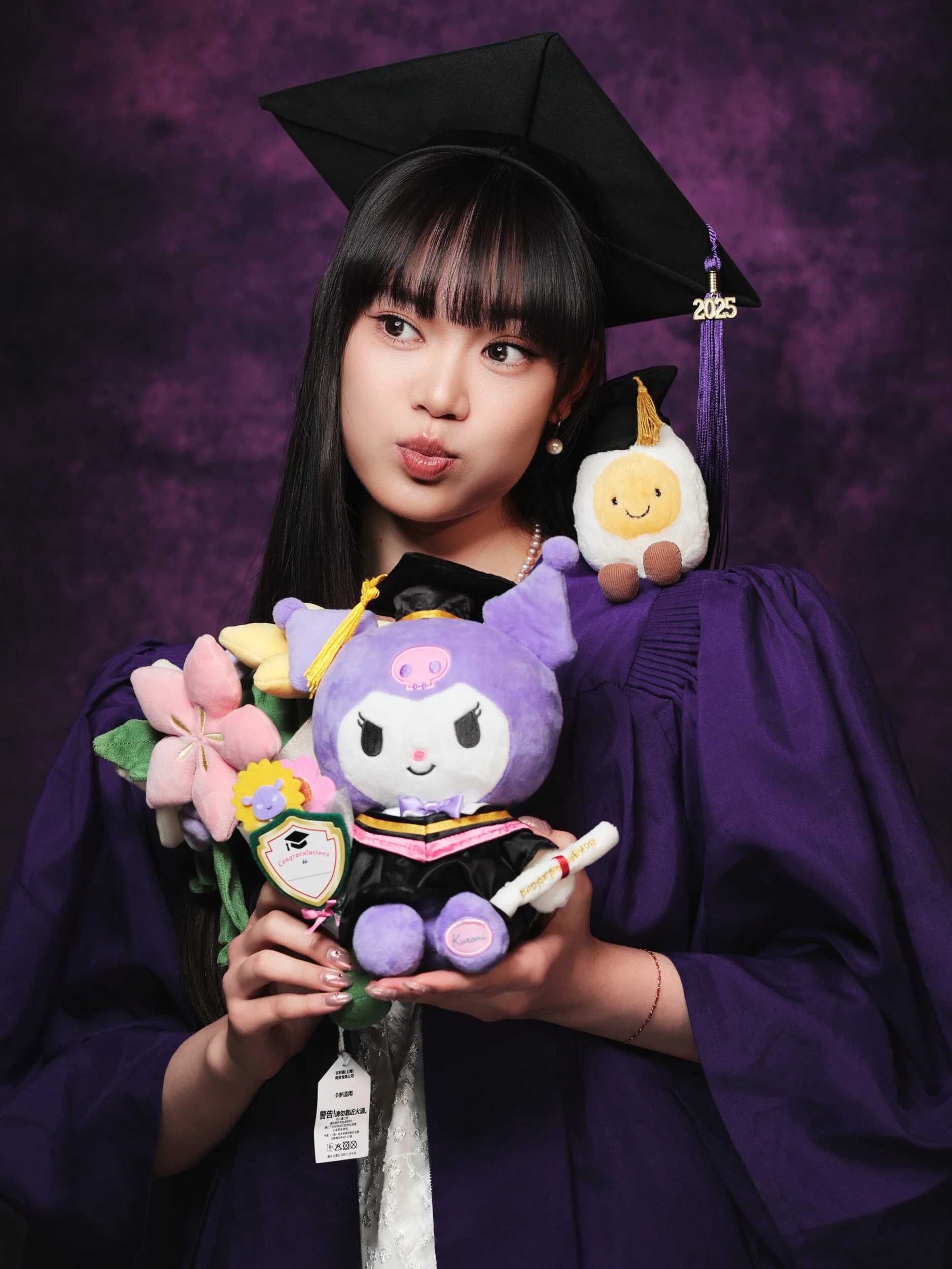 NYU graduation portrait of a woman with bangs puffing her cheeks, holding flowers and a plush toy