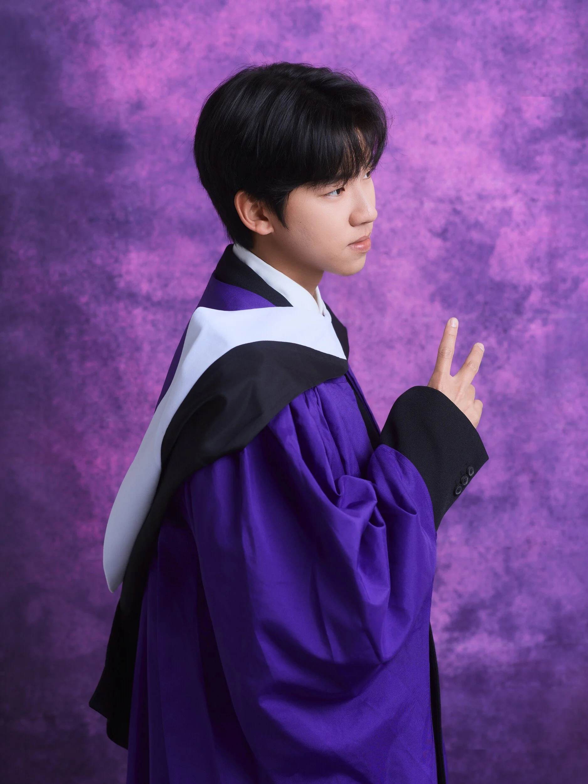 Graduate in profile making a peace sign