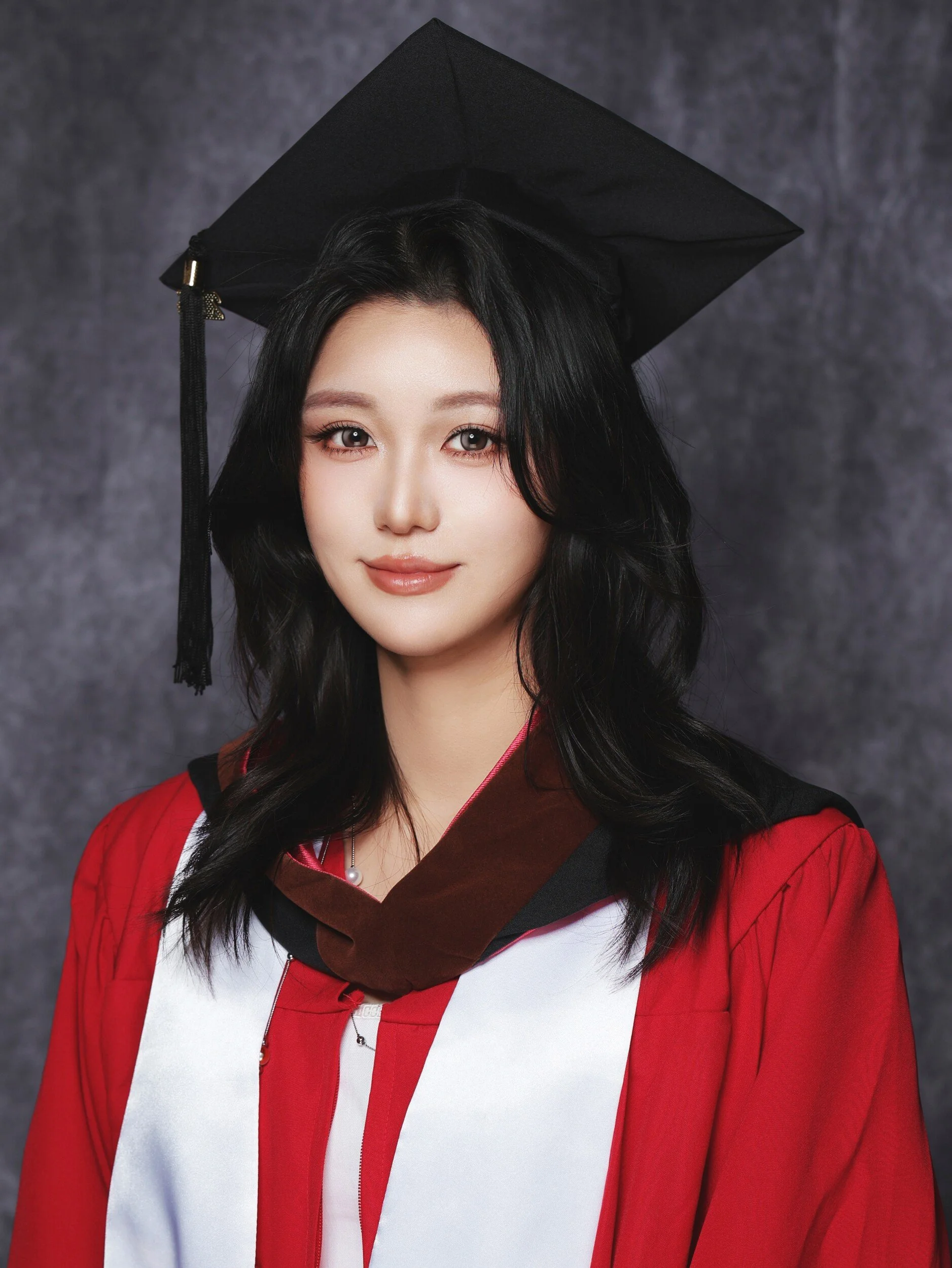 Parsons graduation portrait of a woman in a red gown and cap