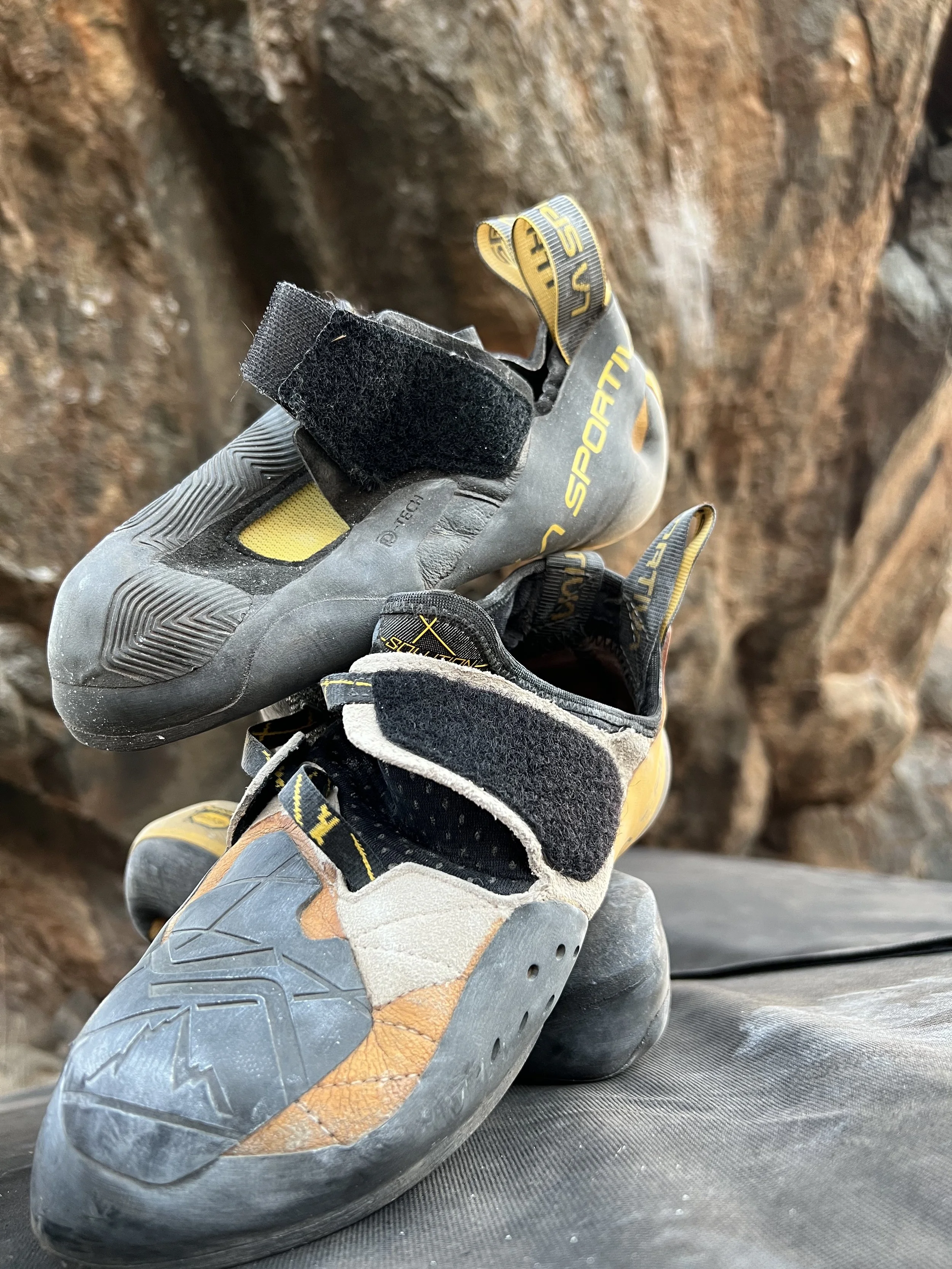 Climbing shoes placed on a rock climbing wall.