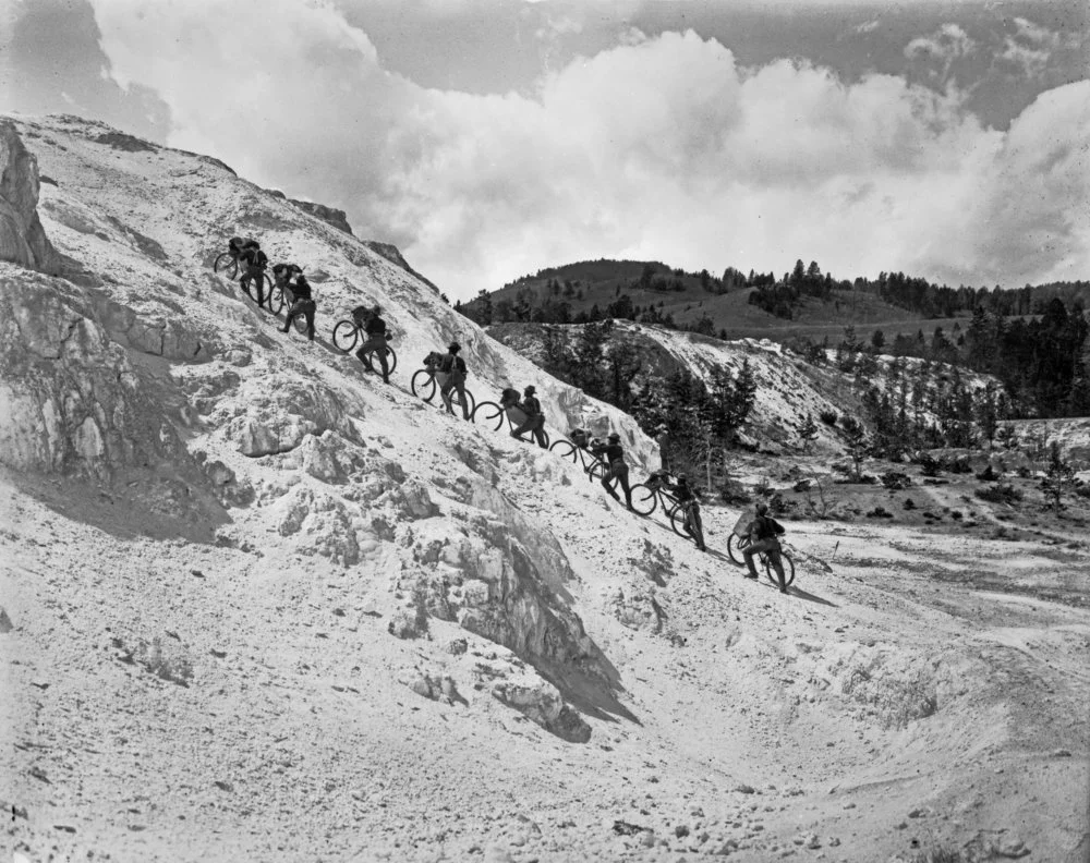 October 7, 1896, 25th Infantry Bicycle Corps pushing their bicycles up the side of Minerva Terrace at Mammoth Hot Springs in Yellowstone National Park. Montana Historical Society, Haynes Foundation Photograph Collection [H-03615].