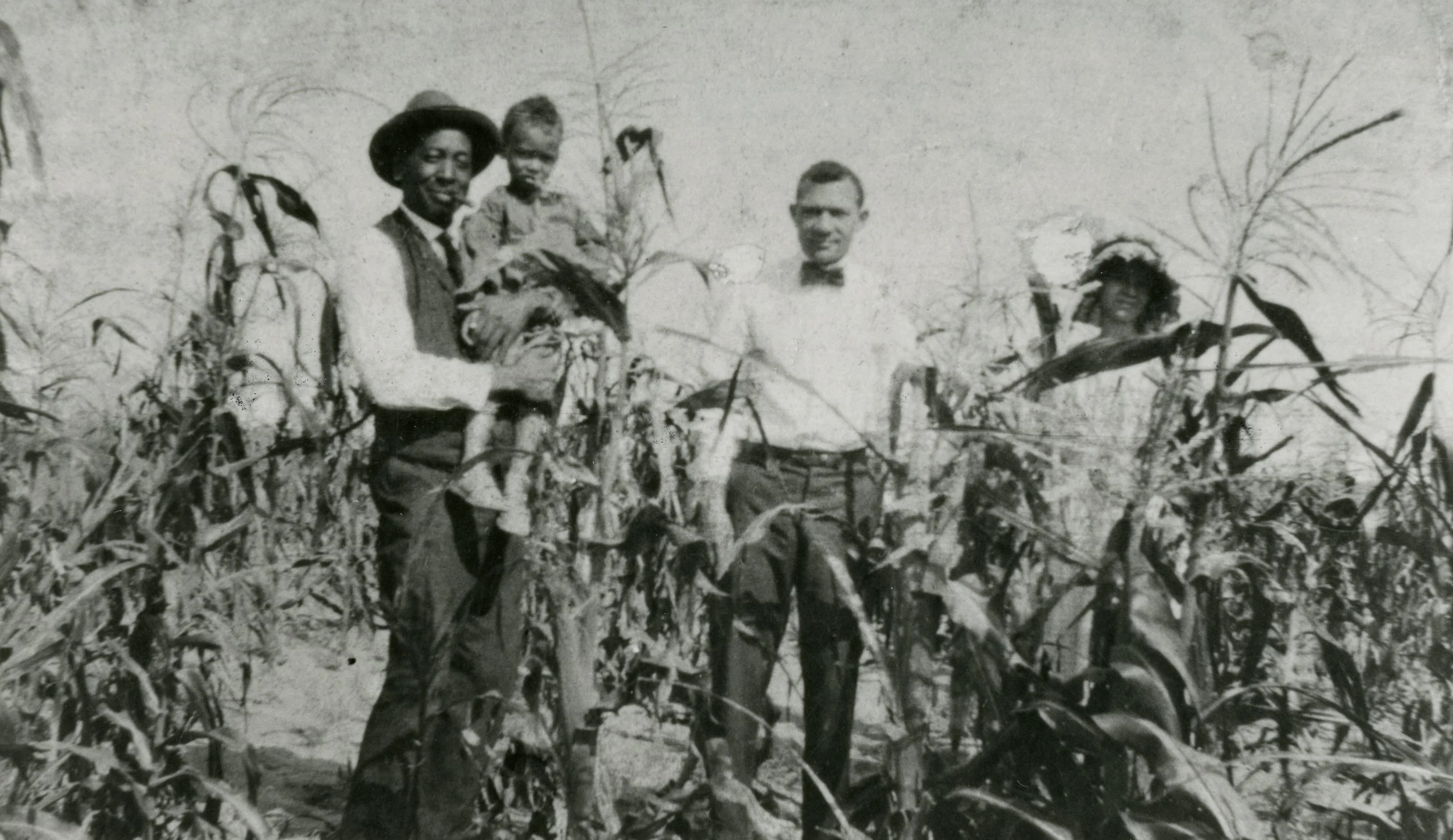 ★ c. 1910-1929, Oliver T. Jackson (holding child), stands with community members in field, Dearfield, CO. Item ID C1_3015.0001.1B, City of Greeley Museums, Permanent Collection.