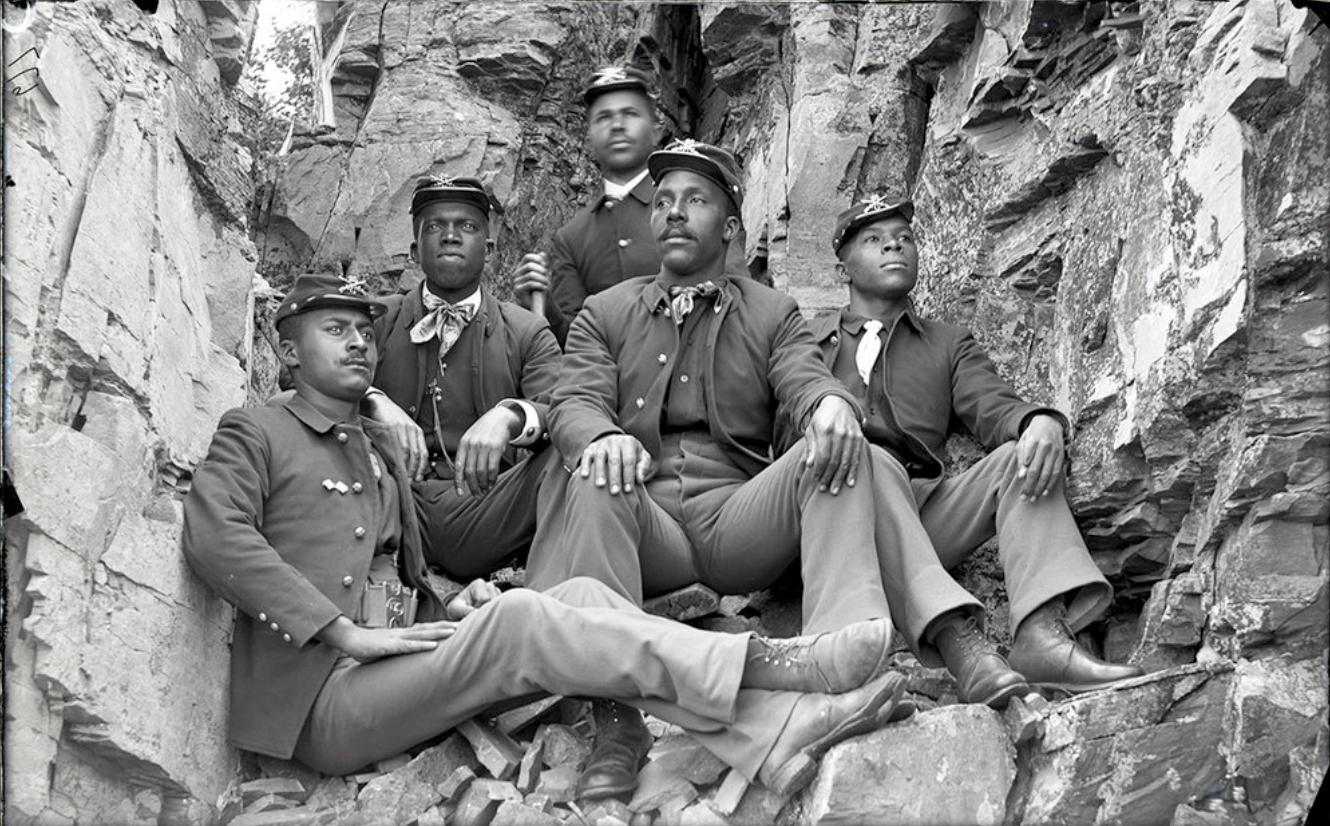 ★ c. 1890s, Group of African American soldiers of the 25th Infantry from Fort Missoula posed in uniform, between the rocks in a canyon. University of Montana Mansfield Library, Morton J. Elrod Papers, Mss 486. Image ID [B.I.j-3].
