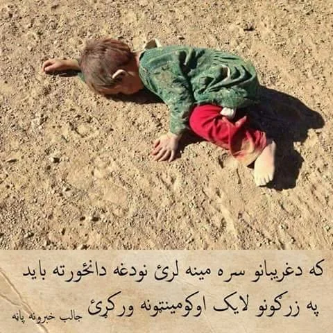 Child lying face down in dirt, wearing a green sweater and red pants.