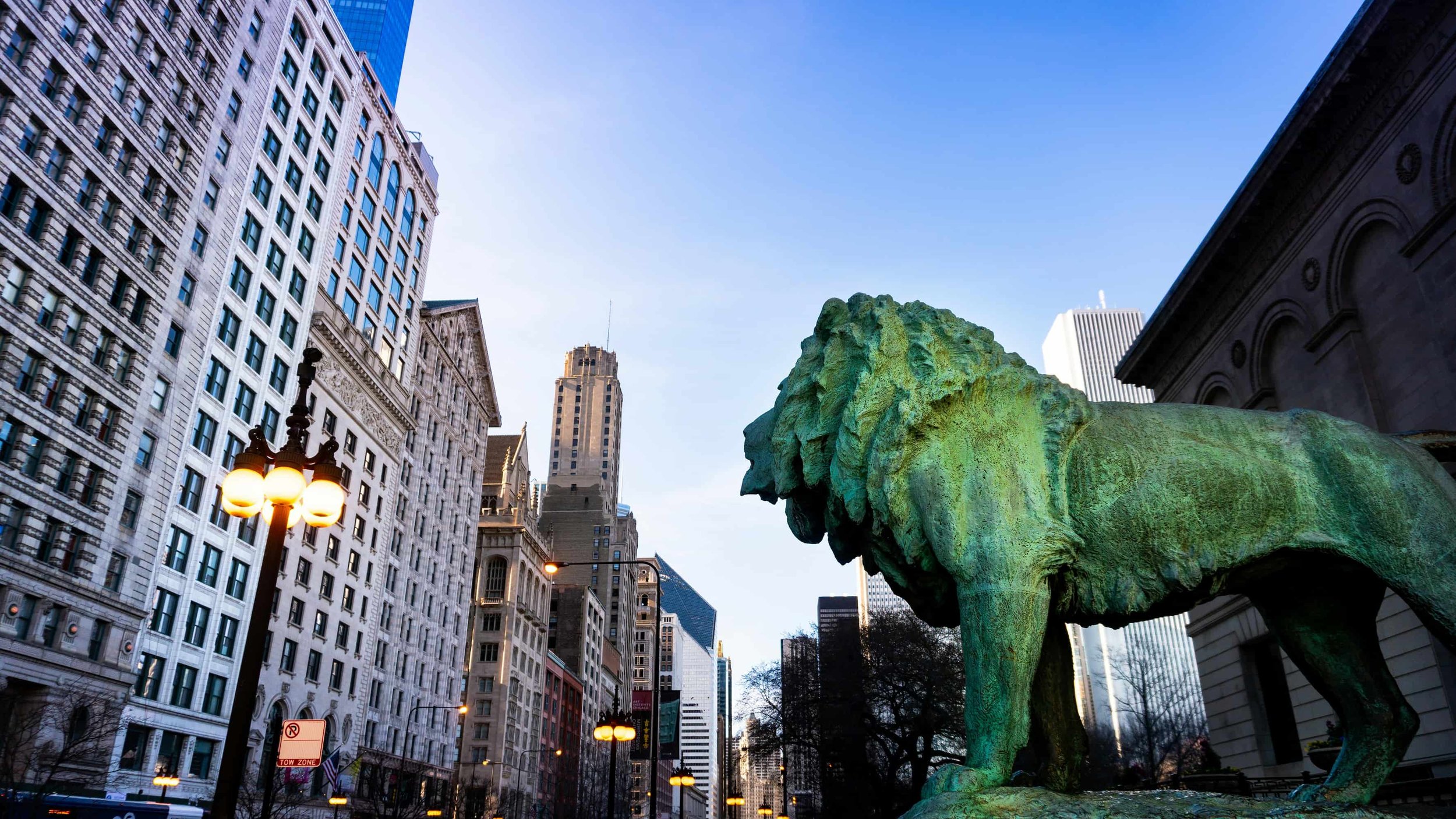 Iconic lion statue outside the Art Institute of Chicago in front of commercial buildings