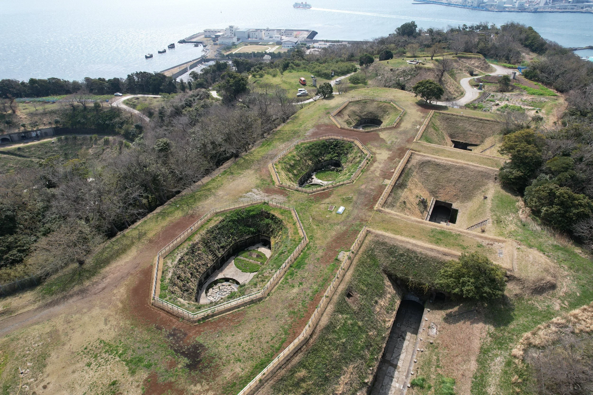 Aerial view of Chiyogasaki Gun Battery Site in Yokosuka — Meiji-era earthworks and tunnels on a forested cliff overlooking Tokyo Bay.