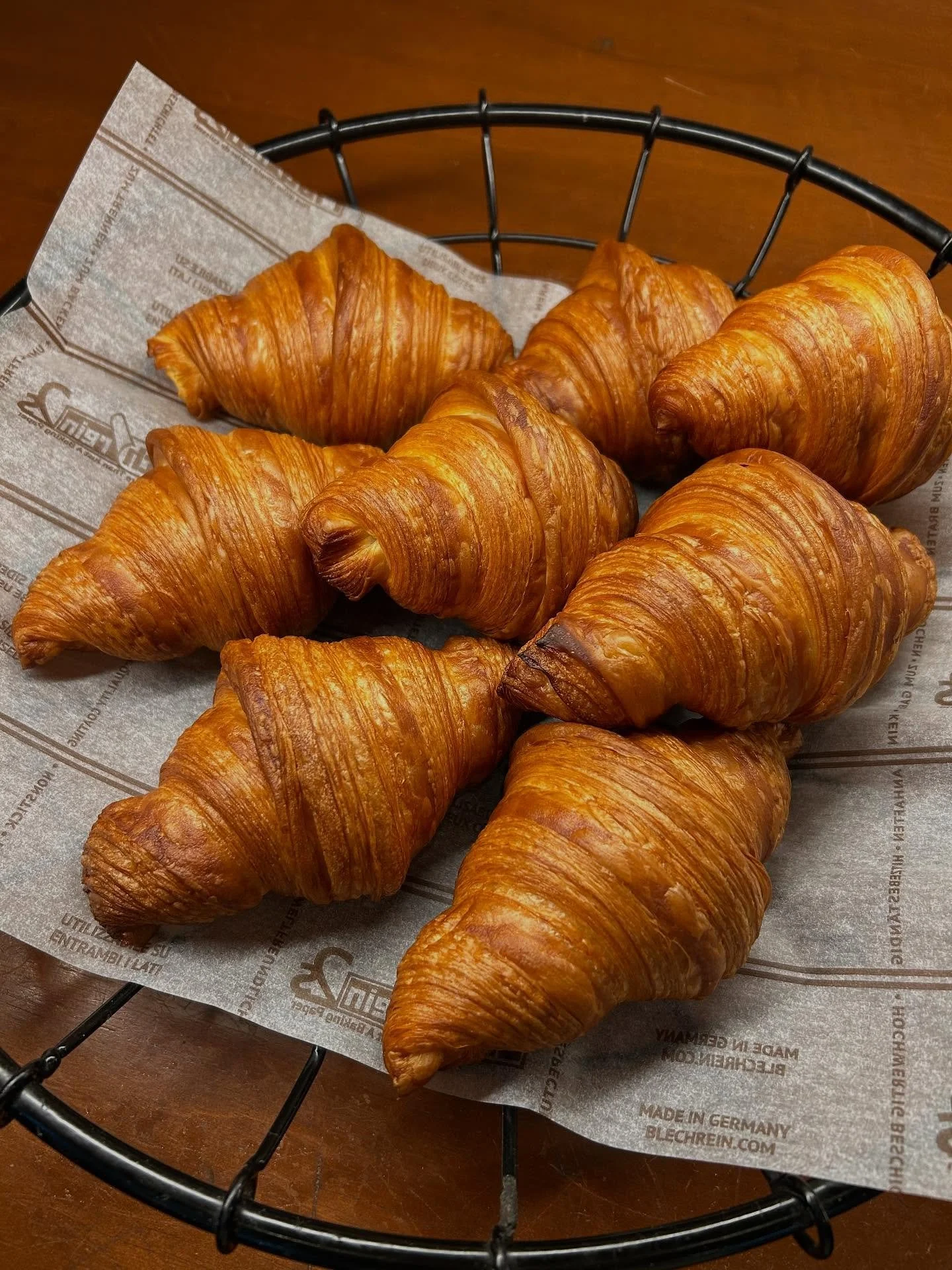 A bowl of udon noodle soup topped with green onions, tempura, beef, and a fish cake, served alongside onigiri rice balls wrapped in seaweed.