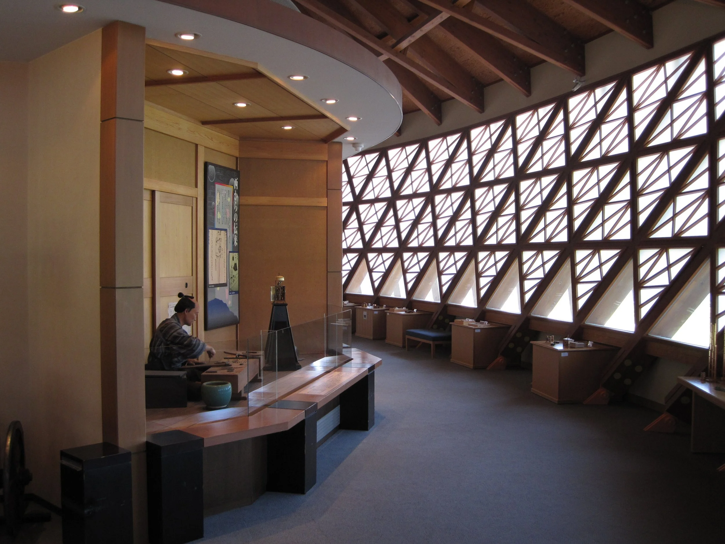 Warm wooden interior of Ohno Karakuri Museum in Kanazawa — lattice windows, soft sea light, and an Edo-era automaton figure at work.
