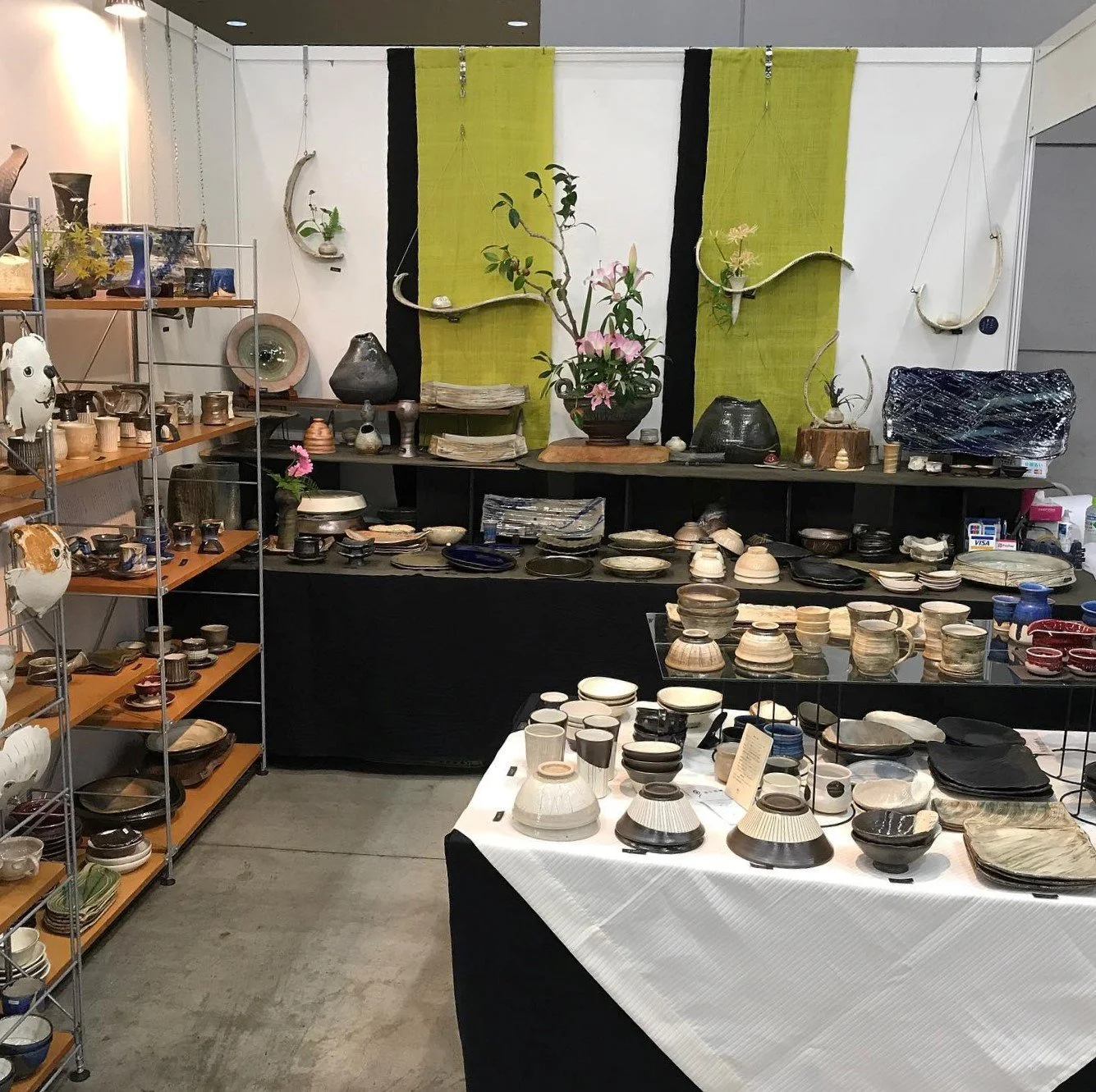 A bowl of udon noodle soup topped with green onions, tempura, beef, and a fish cake, served alongside onigiri rice balls wrapped in seaweed.