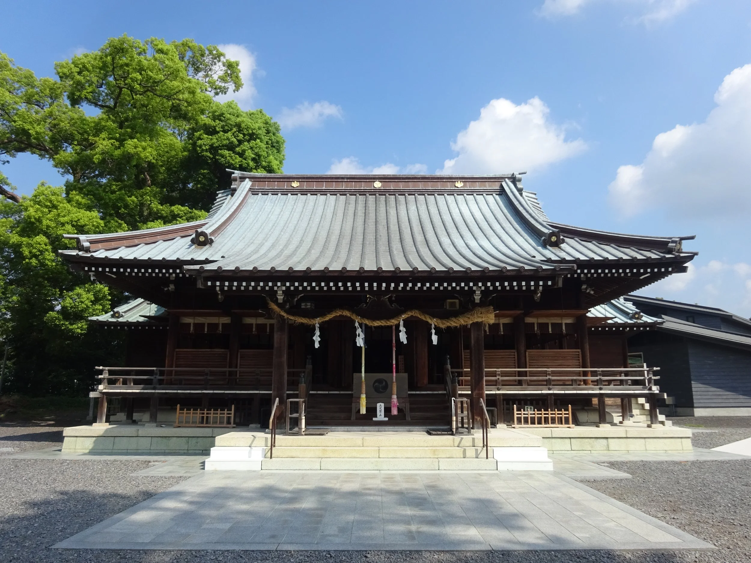Ancient wooden shrine hall of Yaizu Jinja under a summer sky, draped in shimenawa rope — a 1,600-year-old seaside sanctuary in Shizuoka.