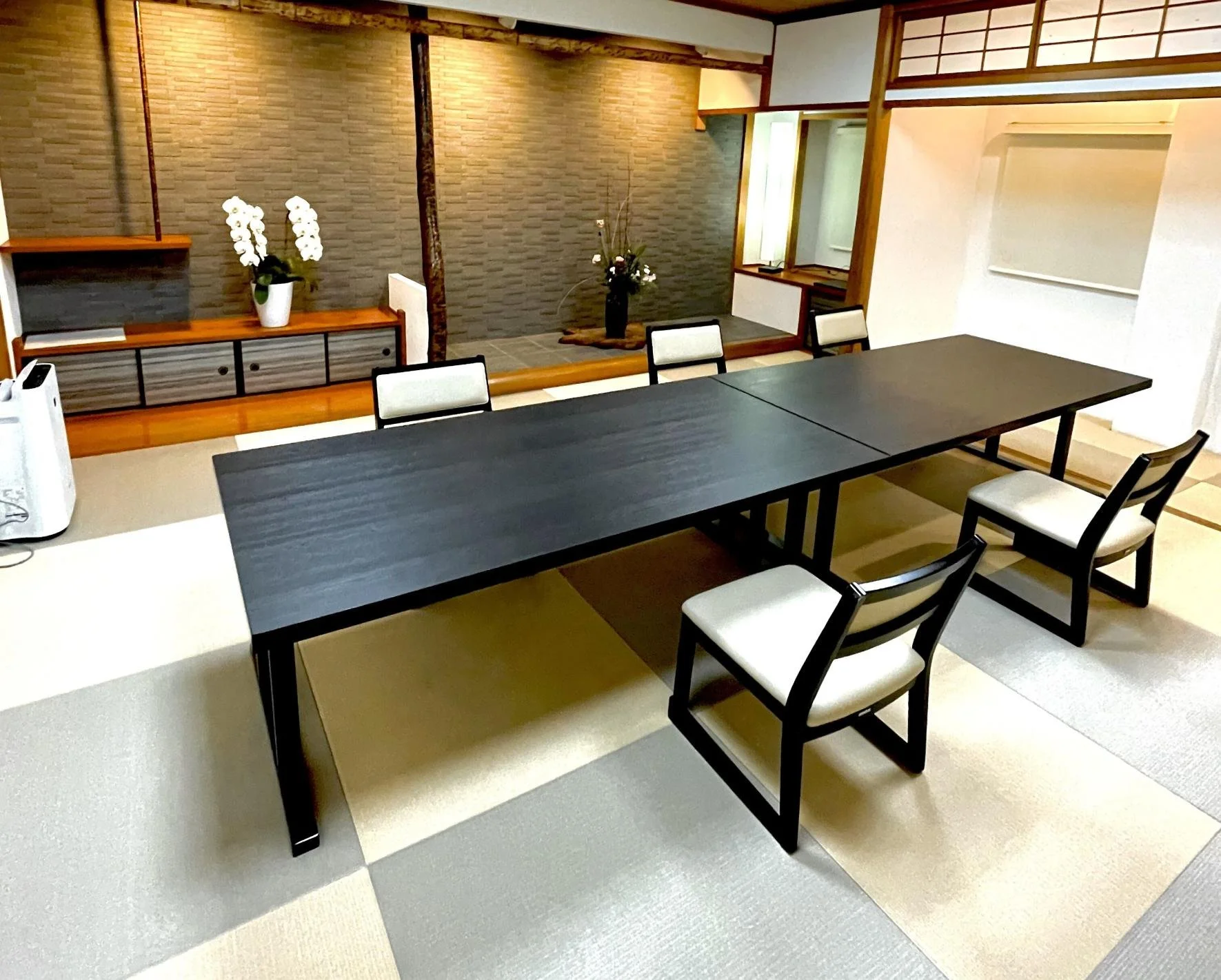 A modern building with glass doors and windows, decorated with flags and signs, including a cartoon tiger mascot wearing a white hat and cape, outdoors on a sunny day with trees in the background.