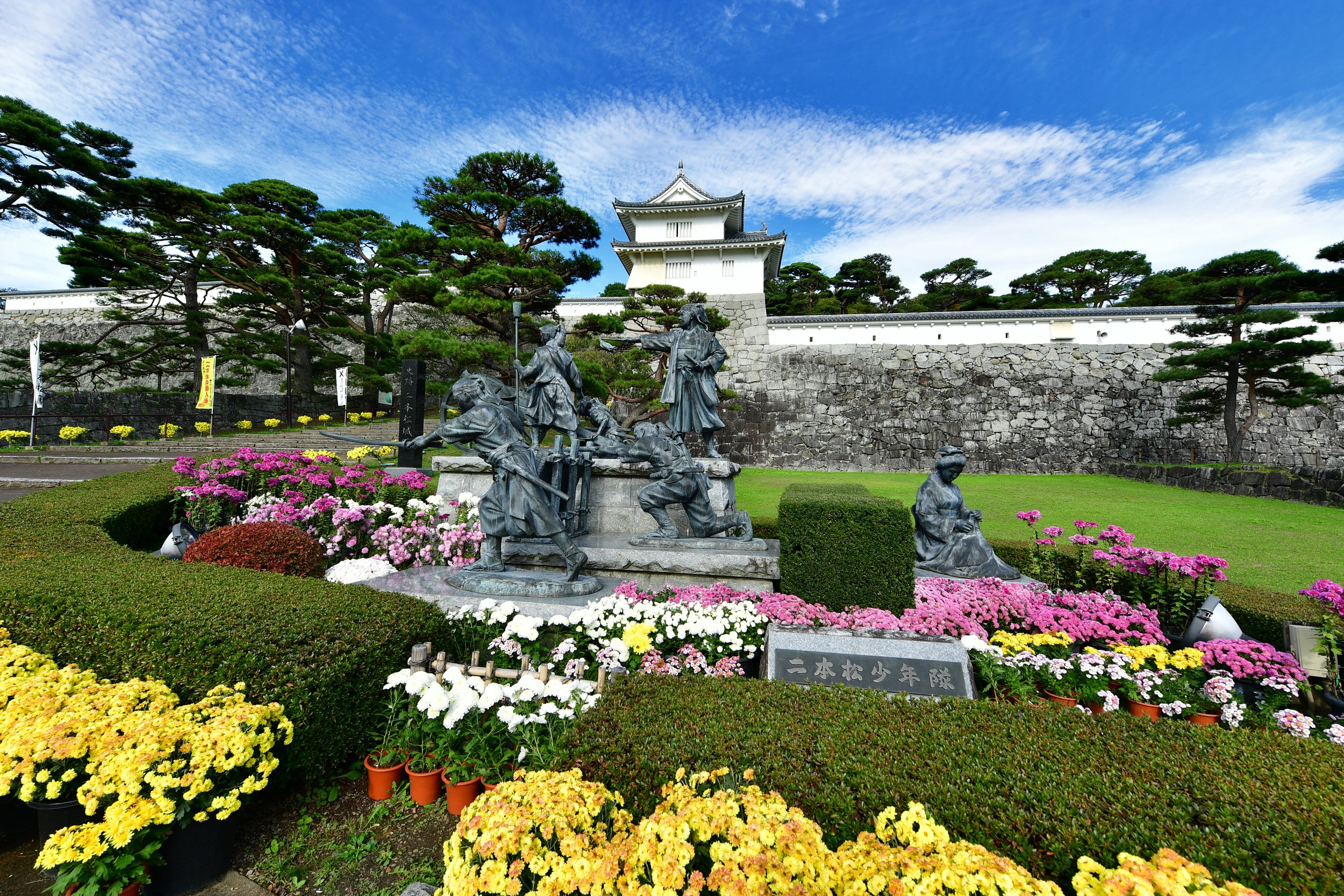 Bronze statues of the Nihonmatsu Boy Warriors before the castle keep ruins — a moving tribute to young samurai who fell in the Boshin War, Fukushima.