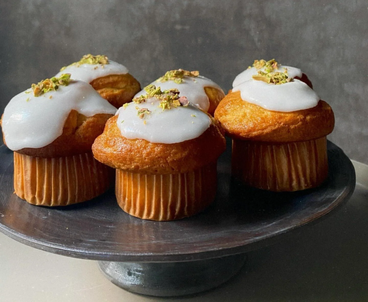 A modern building with glass doors and windows, decorated with flags and signs, including a cartoon tiger mascot wearing a white hat and cape, outdoors on a sunny day with trees in the background.