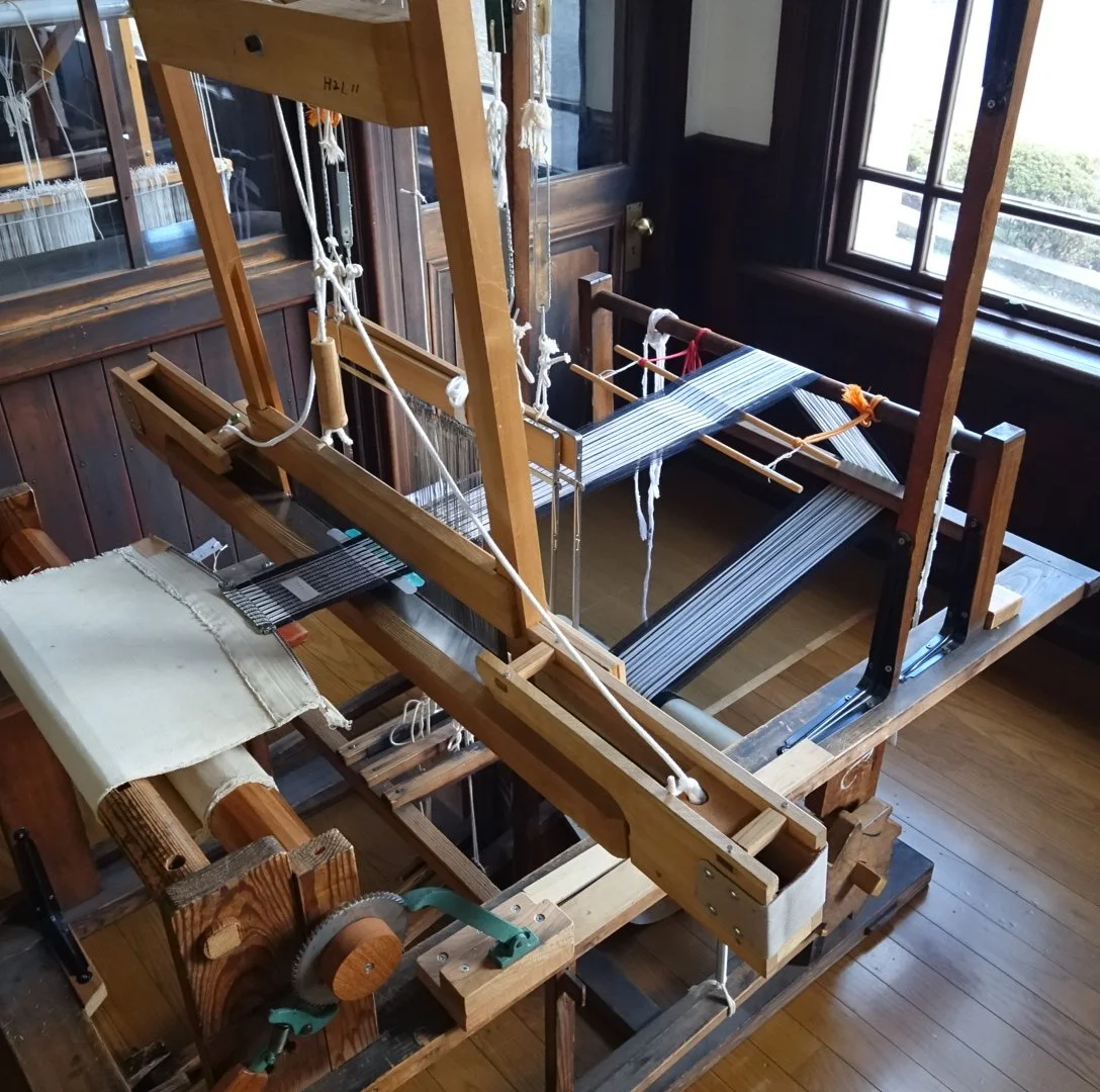 Century-old wooden handloom with warp threads and partially woven silk inside the Taisho-era Okaya Silk Workshop, a registered cultural property in Nagano.