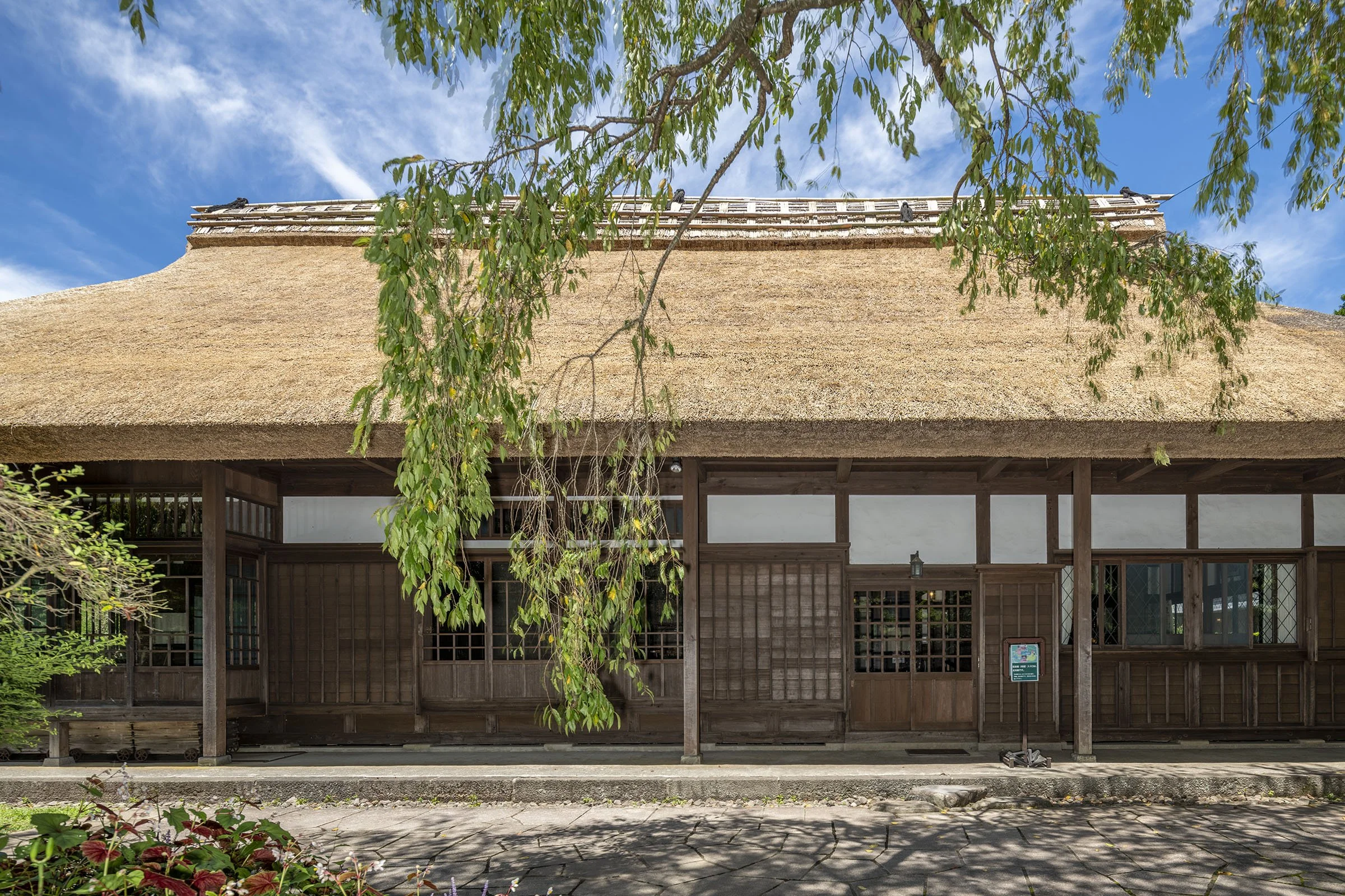 A 300-year-old thatched-roof imperial residence framed by a weeping cherry tree in Gotemba — a historic hidden gem at the foot of Mt. Fuji.