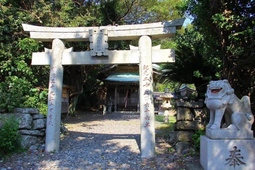 Stone torii gate and guardian komainu statue at the entrance to Komodahama Shrine, a quiet historic shrine on Tsushima Island commemorating the 1274 Mongol invasion.