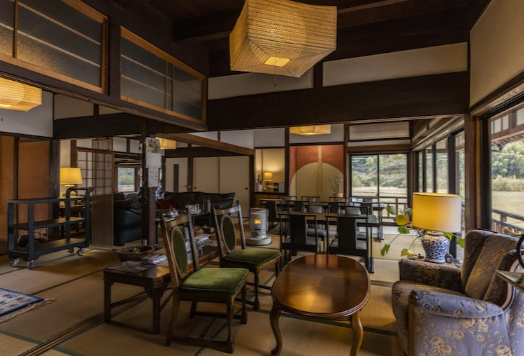 A modern building with glass doors and windows, decorated with flags and signs, including a cartoon tiger mascot wearing a white hat and cape, outdoors on a sunny day with trees in the background.