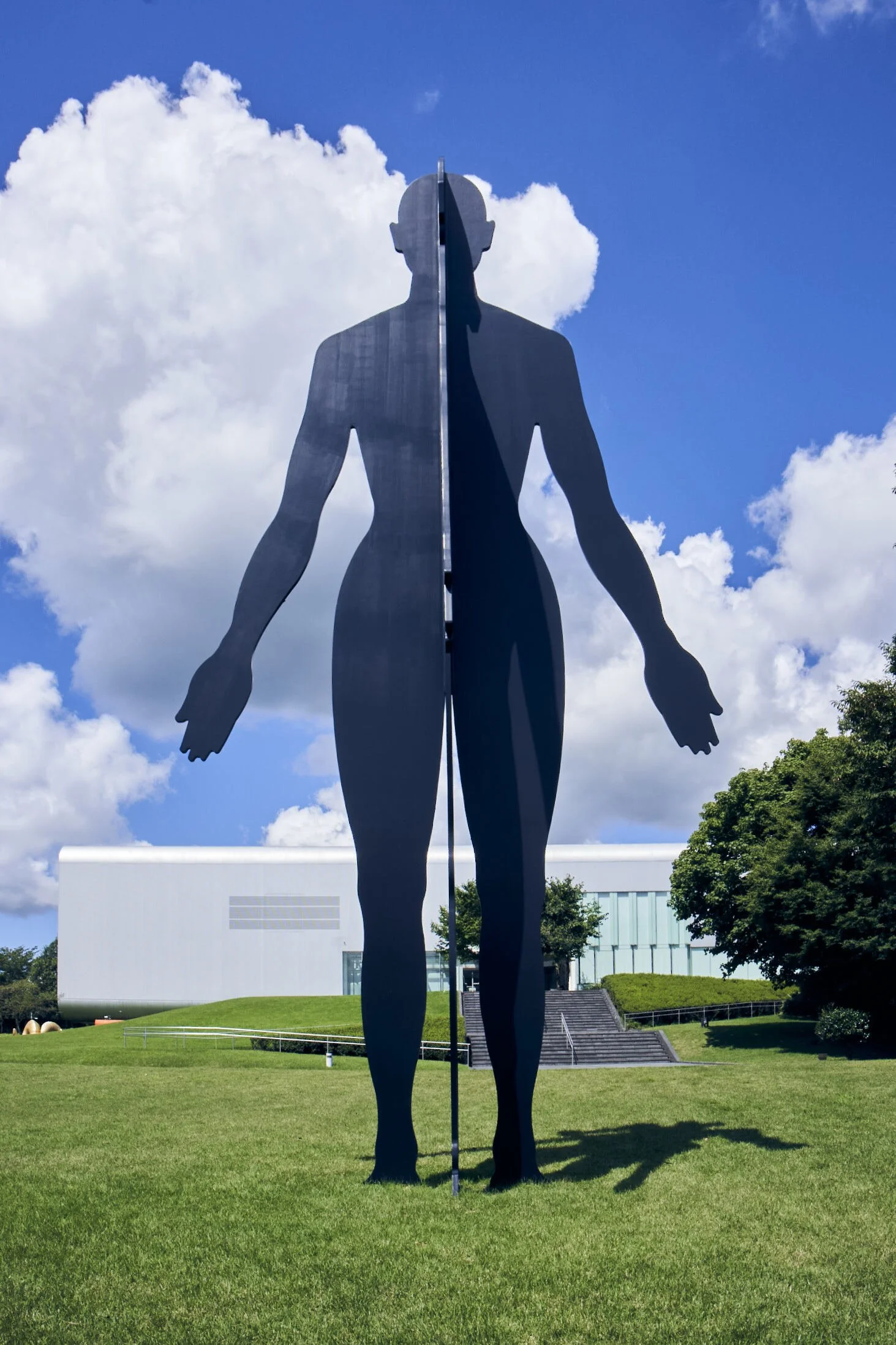 Jonathan Borofsky's towering black silhouette sculpture "Man and Woman" against blue sky at Kirishima Open-Air Museum, Kagoshima.