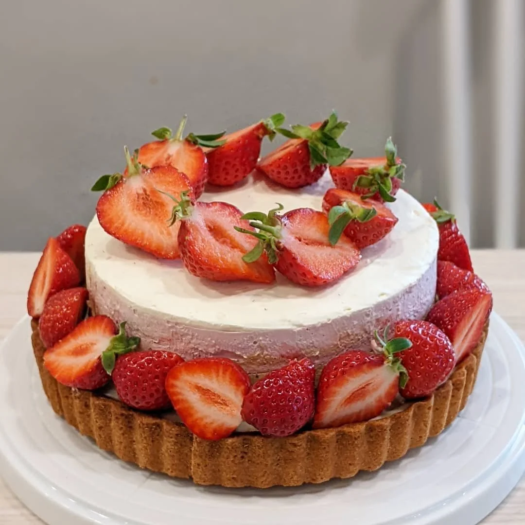 Display of packaged cookies with labels that feature a cartoon character holding a leaf, on a wooden surface.