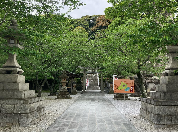 Stone-lined path leading to the torii and forested stairway of Hinomine Shrine, a 1,160-year-old sanctuary in Kitakyushu, Japan.
