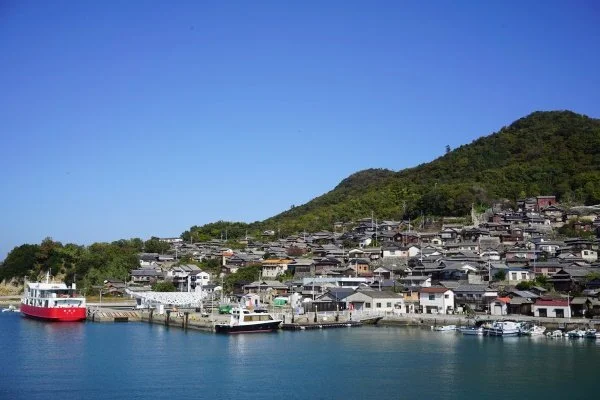 Quiet harbor village on Megijima or Ogijima with moored boats and hillside houses along the calm Seto Inland Sea near Takamatsu.