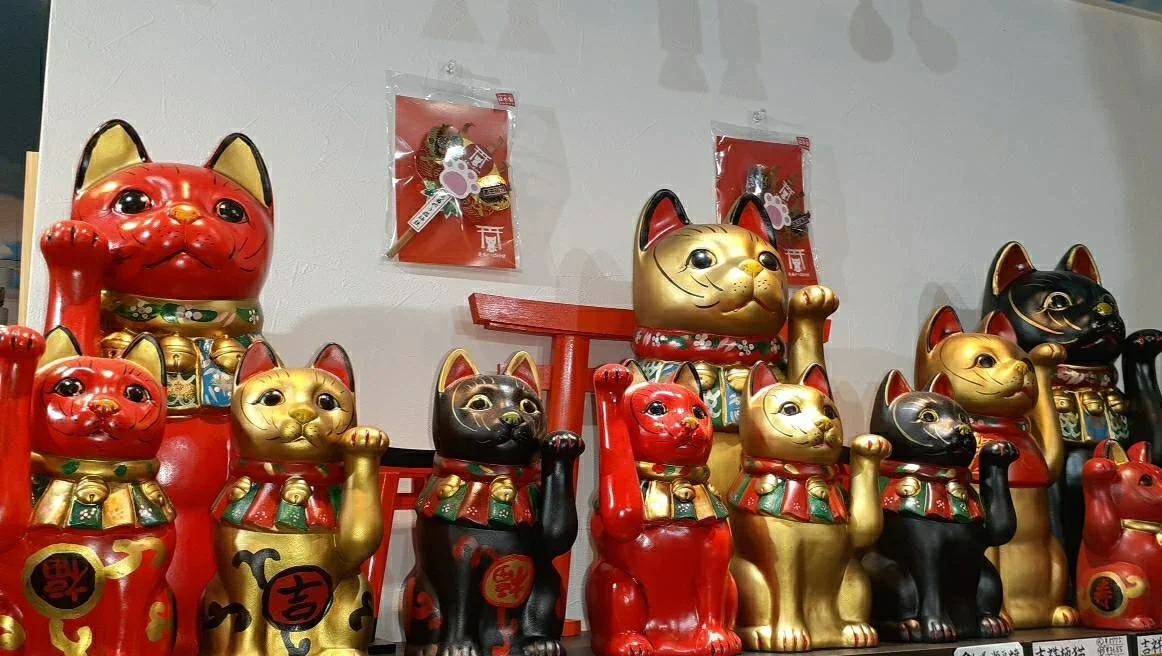 Rows of red and gold maneki-neko figurines at Nagasaki's Omagari Neko Shrine — Japan's smallest indoor cat shrine near Meganebashi.