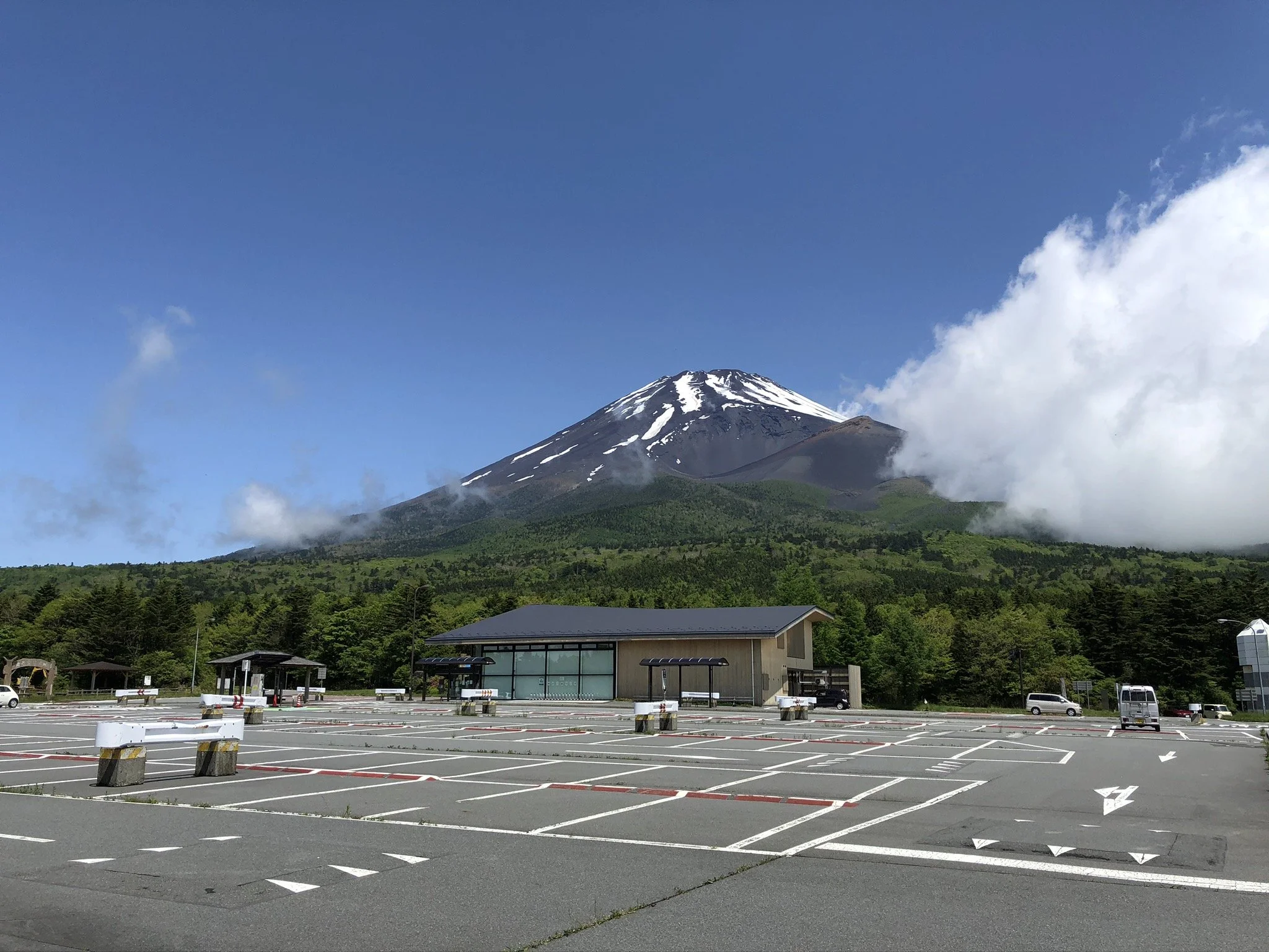 Mt. Fuji rising above the forest at Mizugatsuka Park — a sky-high viewpoint at 1,450m with the Hoei Crater in full view.