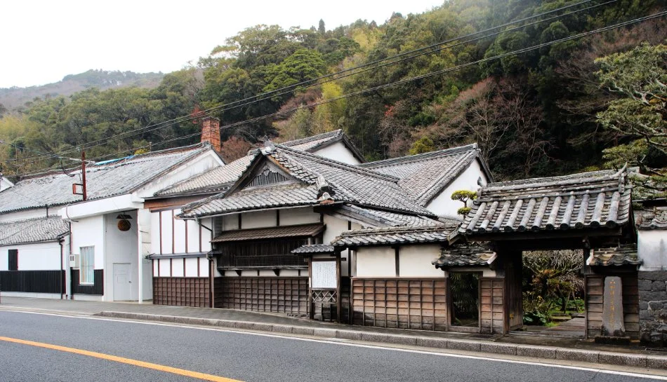 Edo-period Senryu Brewery in Emukae, Sasebo — white plaster walls and tiled roofs beneath a wooded Nagasaki hillside.