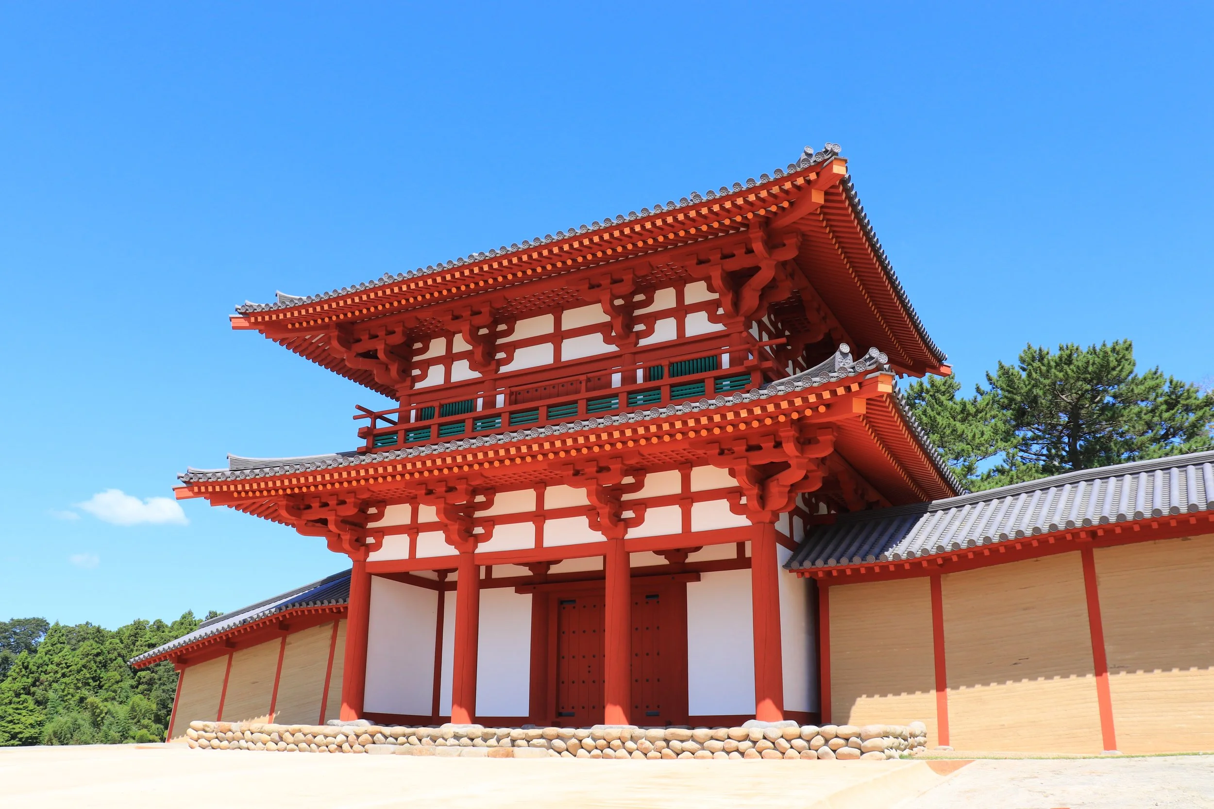 Reconstructed vermilion double-story south gate of ancient Tagajo fortress under clear blue sky — a 1,300-year-old landmark reborn in Miyagi, Japan.
