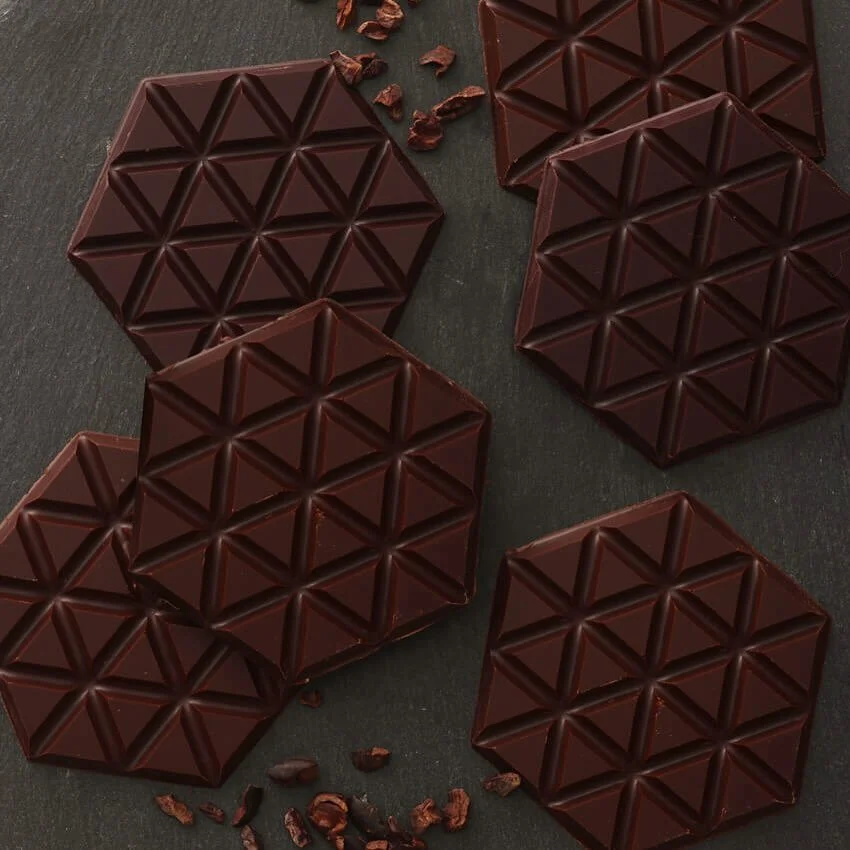 A modern building with glass doors and windows, decorated with flags and signs, including a cartoon tiger mascot wearing a white hat and cape, outdoors on a sunny day with trees in the background.