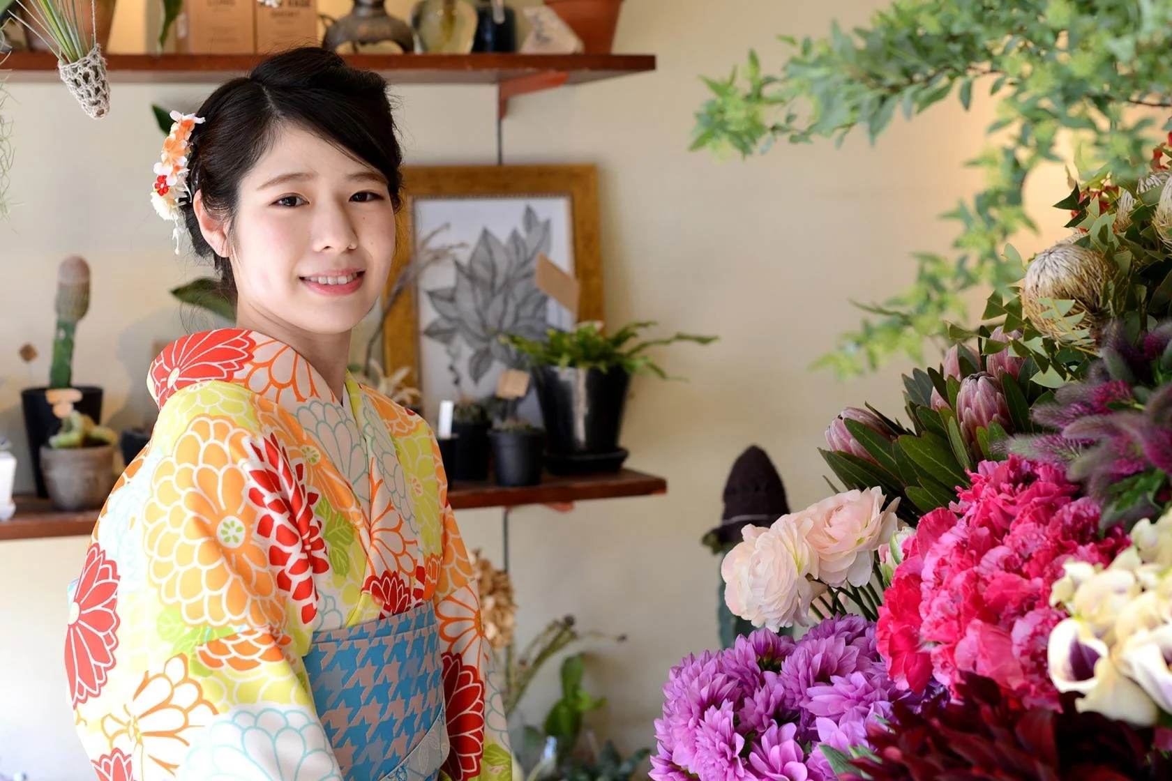 A bowl of udon noodle soup topped with green onions, tempura, beef, and a fish cake, served alongside onigiri rice balls wrapped in seaweed.