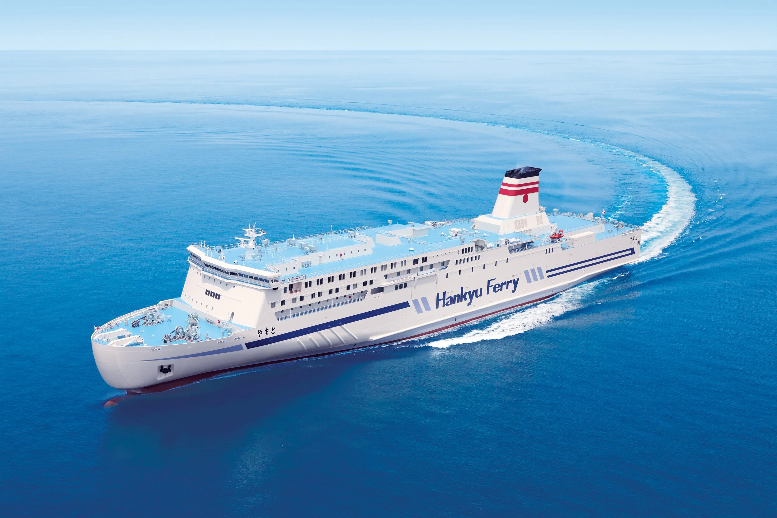 Hankyu Ferry gliding across the calm blue Seto Inland Sea, carrying overnight travelers from Kansai to Kyushu, Japan.