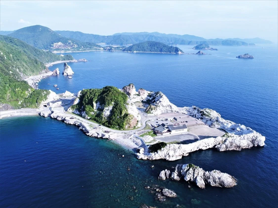 Aerial view of Shirasaki Ocean Park's white limestone headland meeting turquoise and cobalt sea in Yura, Wakayama — the Aegean Sea of Japan.