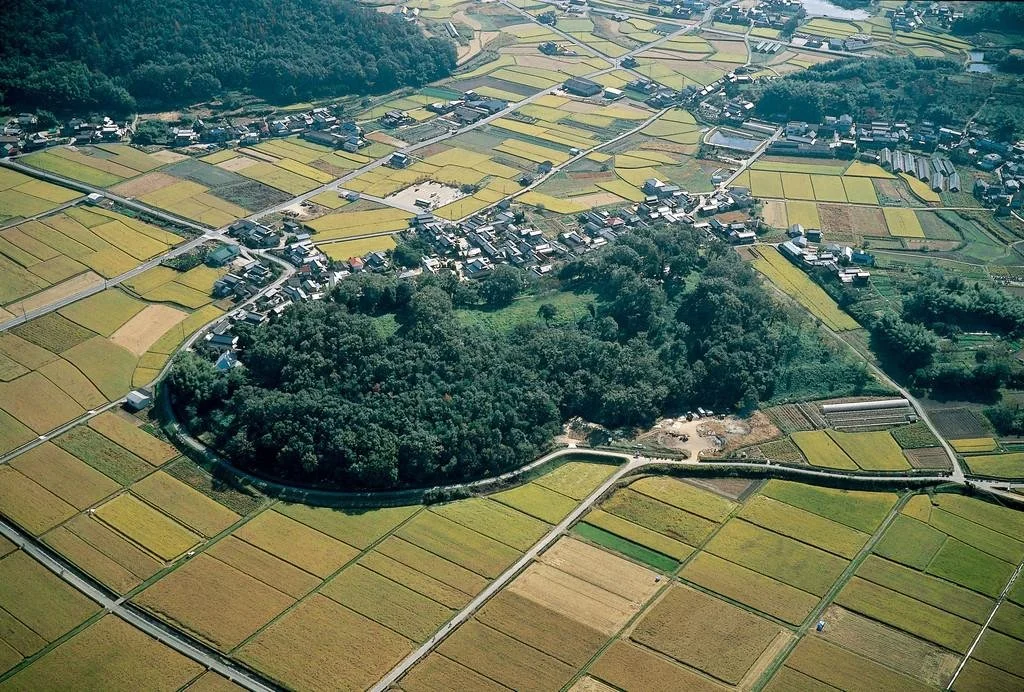 Aerial view of Tsukuriyama Tumulus, Japan's fourth largest keyhole-shaped kofun, surrounded by Okayama's peaceful countryside.