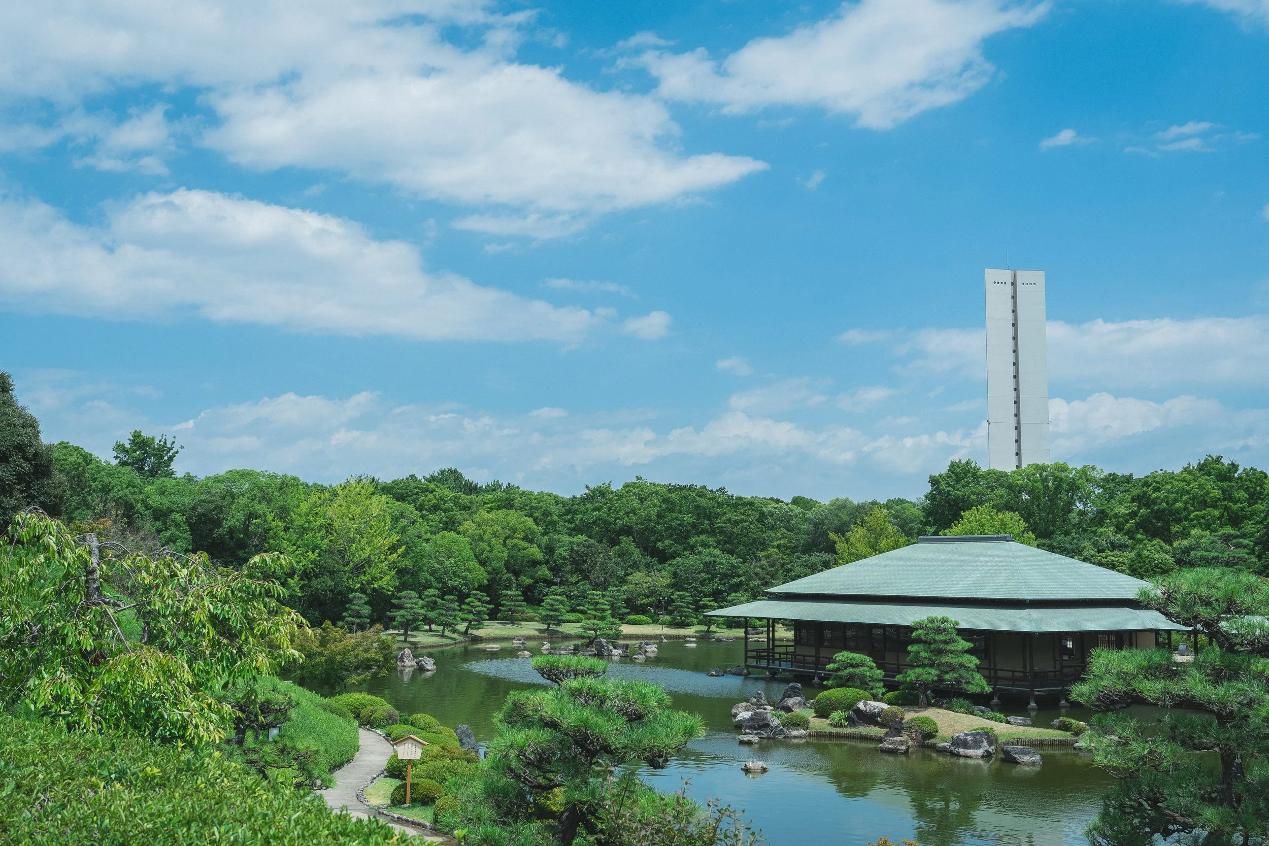 A serene Japanese garden pond with a traditional pavilion, manicured pines, and koi — a hidden historical gem in Sakai, Osaka.