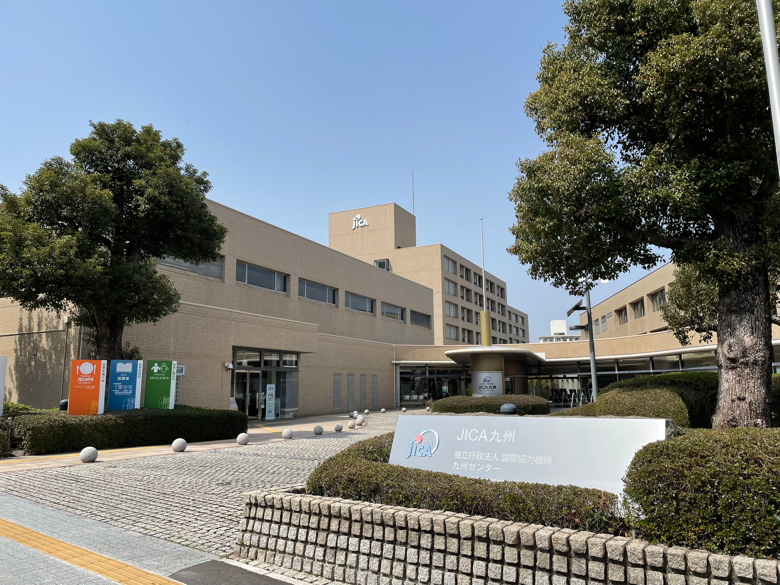 JICA Kyushu building exterior surrounded by lush greenery at Yahata Kokusaimura — an international cooperation center in Kitakyushu.