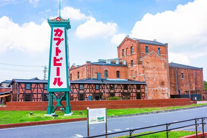 Historic Kabuto Beer brewery in Handa, Aichi — Meiji-era red brick and half-timbered facade under a clear blue sky.