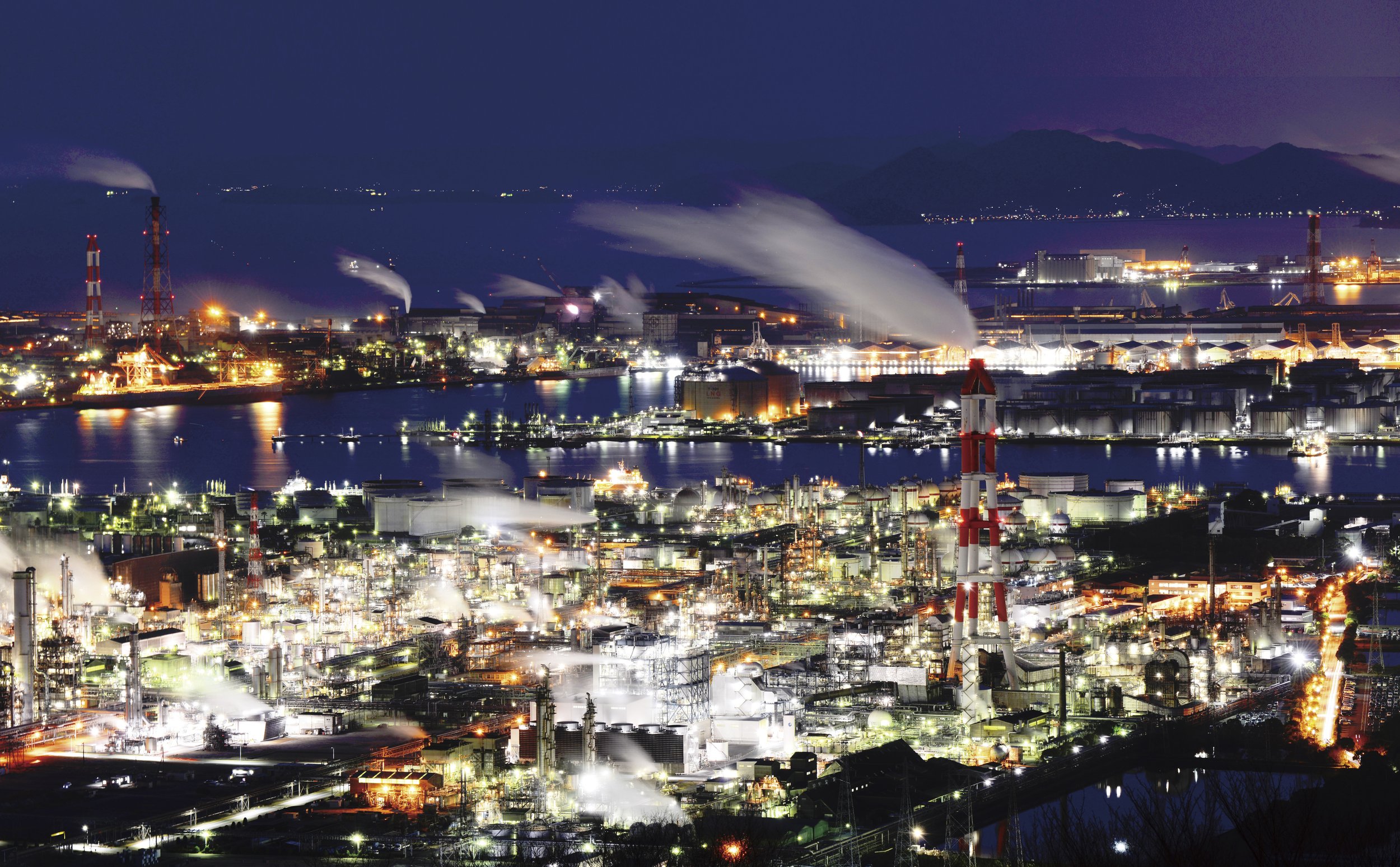 Kurashiki's Mizushima industrial complex glowing like a jewel box at night, viewed from Mt. Washu Skyline observatory over the Seto Inland Sea.
