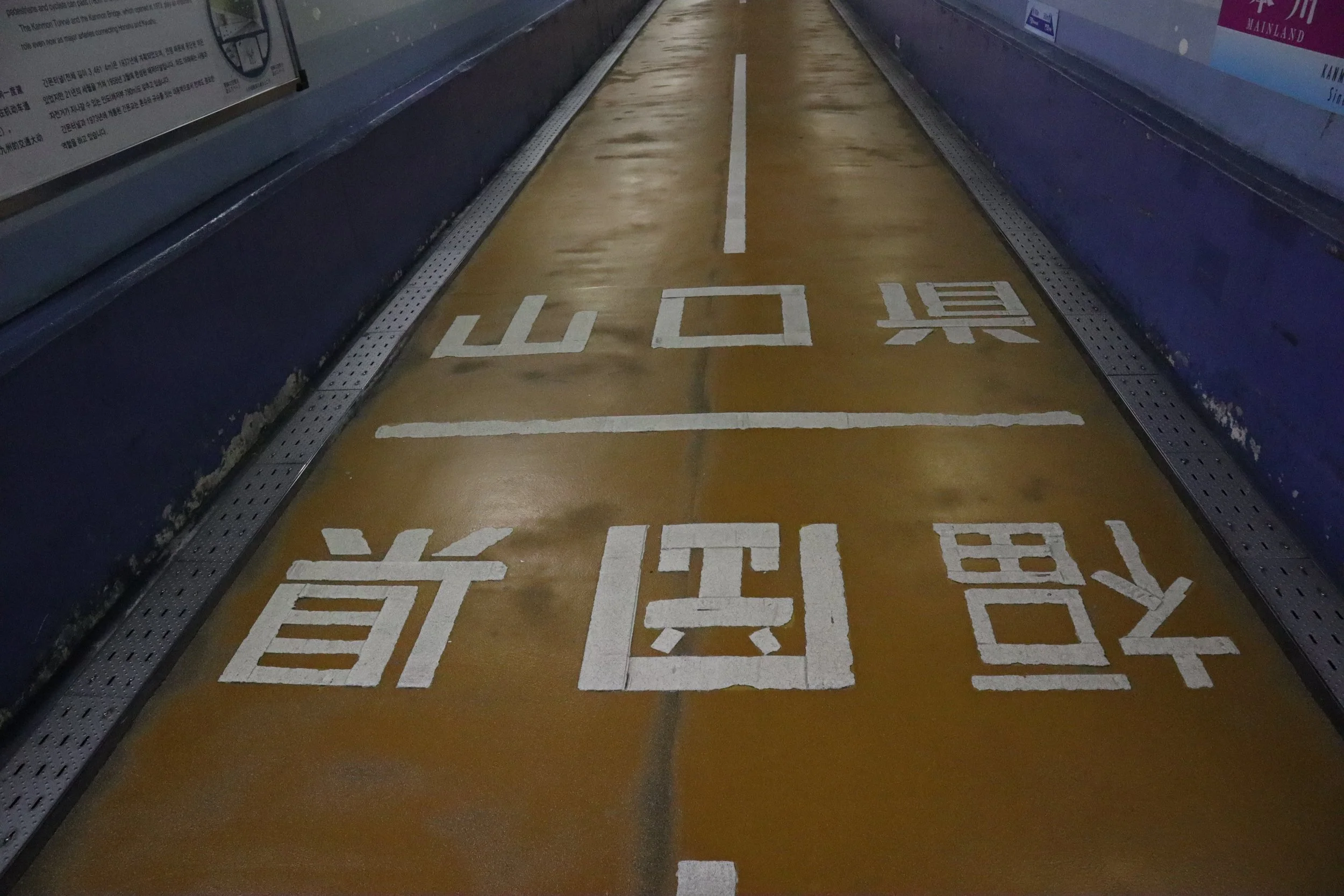 Painted border line on the floor of the Kanmon Pedestrian Tunnel dividing Fukuoka and Yamaguchi prefectures beneath the sea in Japan.
