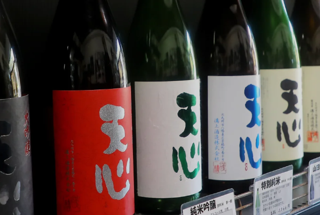 Bottles of Tenshin sake lined up on a shelf at Mizokami Sake Brewery, a 180-year-old Kitakyushu brewery crafted with Mt. Sarakura spring water.