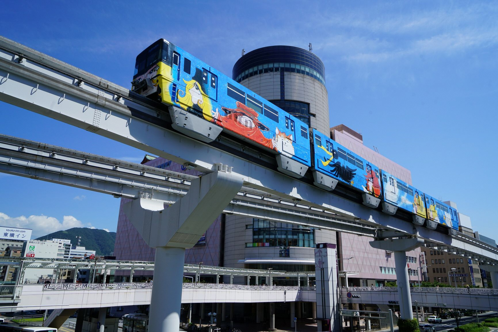 Kitakyushu Monorail seen from below against the Kokura city skyline — Japan's first urban monorail and a local hidden gem.