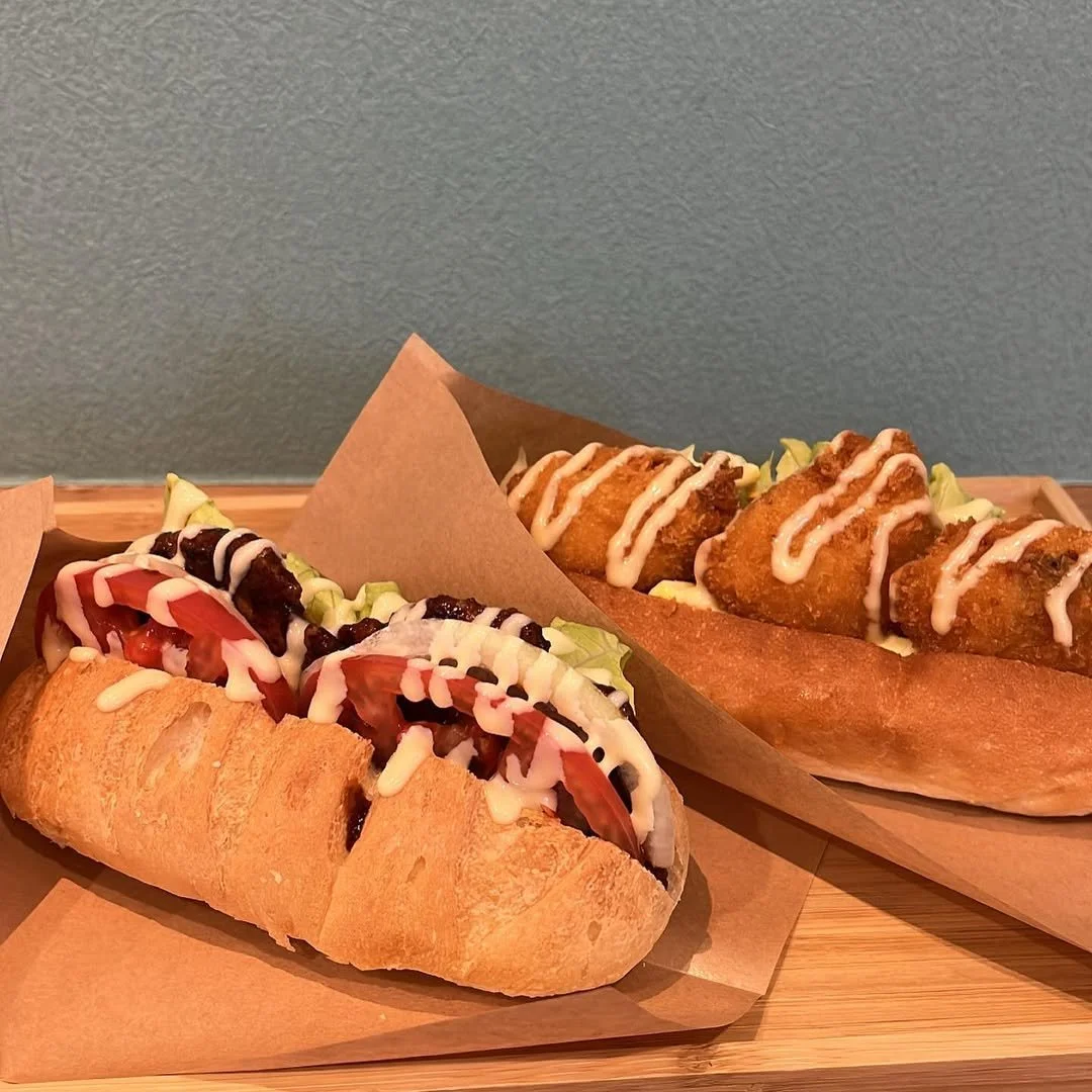 Display of packaged cookies with labels that feature a cartoon character holding a leaf, on a wooden surface.