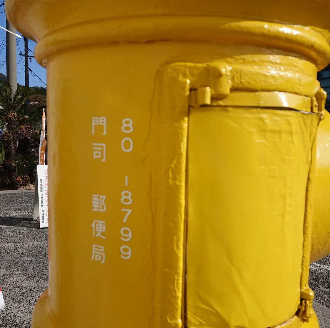 Bright yellow banana-shaped postbox in Mojiko Retro, Kitakyushu — a functional postbox honoring Japan's historic banana auction port.
