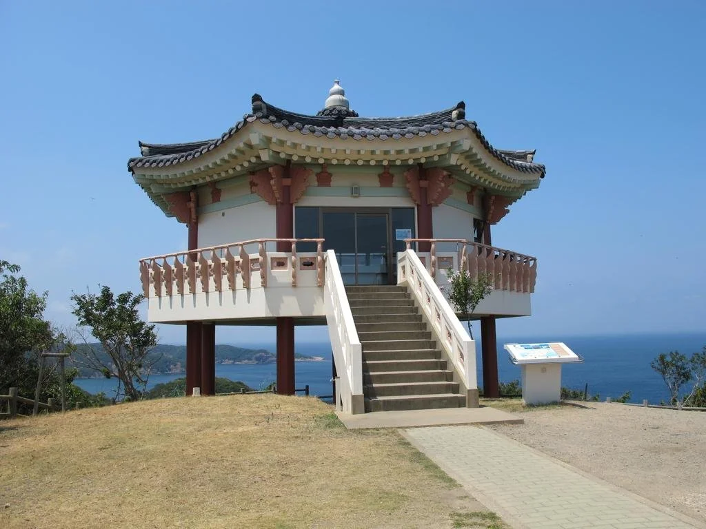 Korean-style pavilion at the Korea Observatory in Tsushima, overlooking the sea toward Busan under clear blue skies.