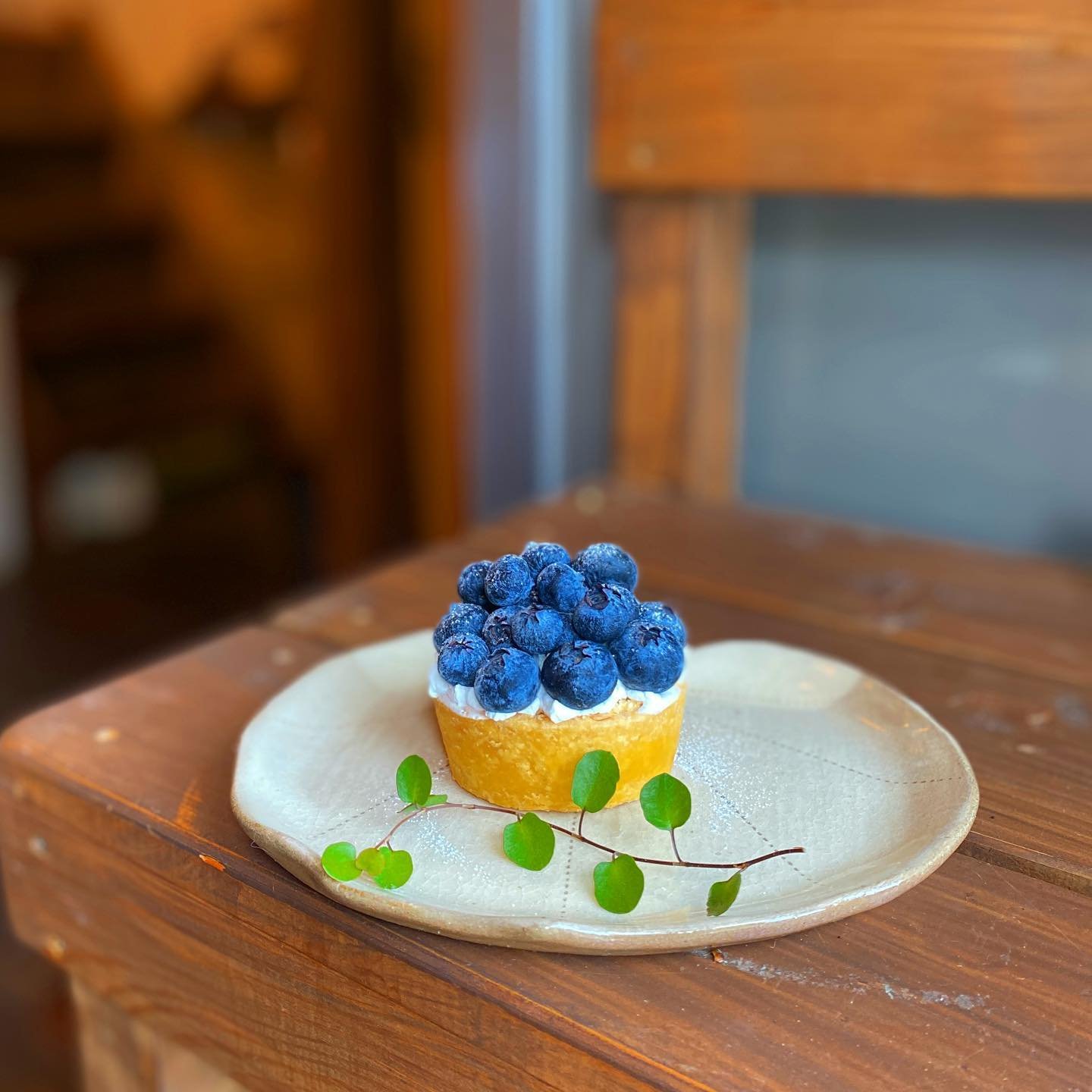 A bowl of udon noodle soup topped with green onions, tempura, beef, and a fish cake, served alongside onigiri rice balls wrapped in seaweed.