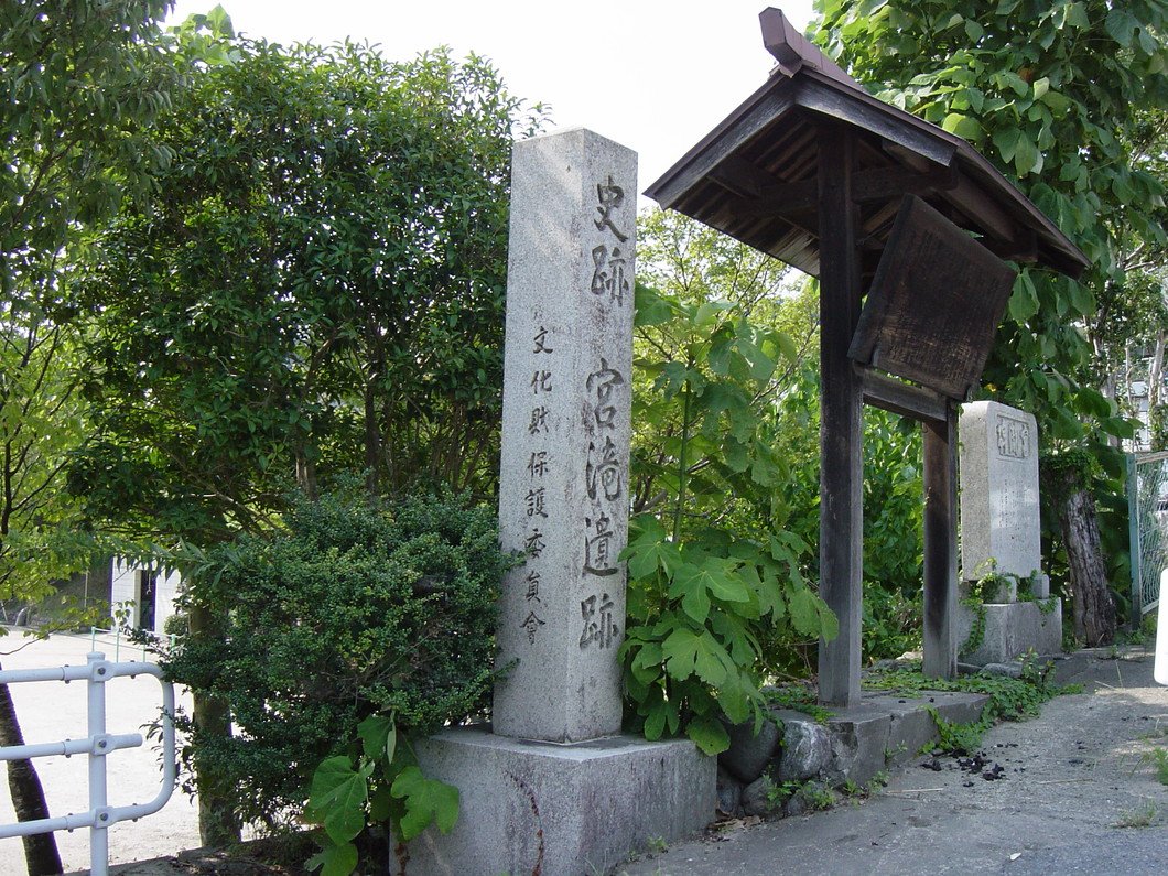 Stone marker of the Miyataki Site among lush greenery near the Yoshino River in Nara—a nationally designated Historic Site preserving layers of Japan's past.